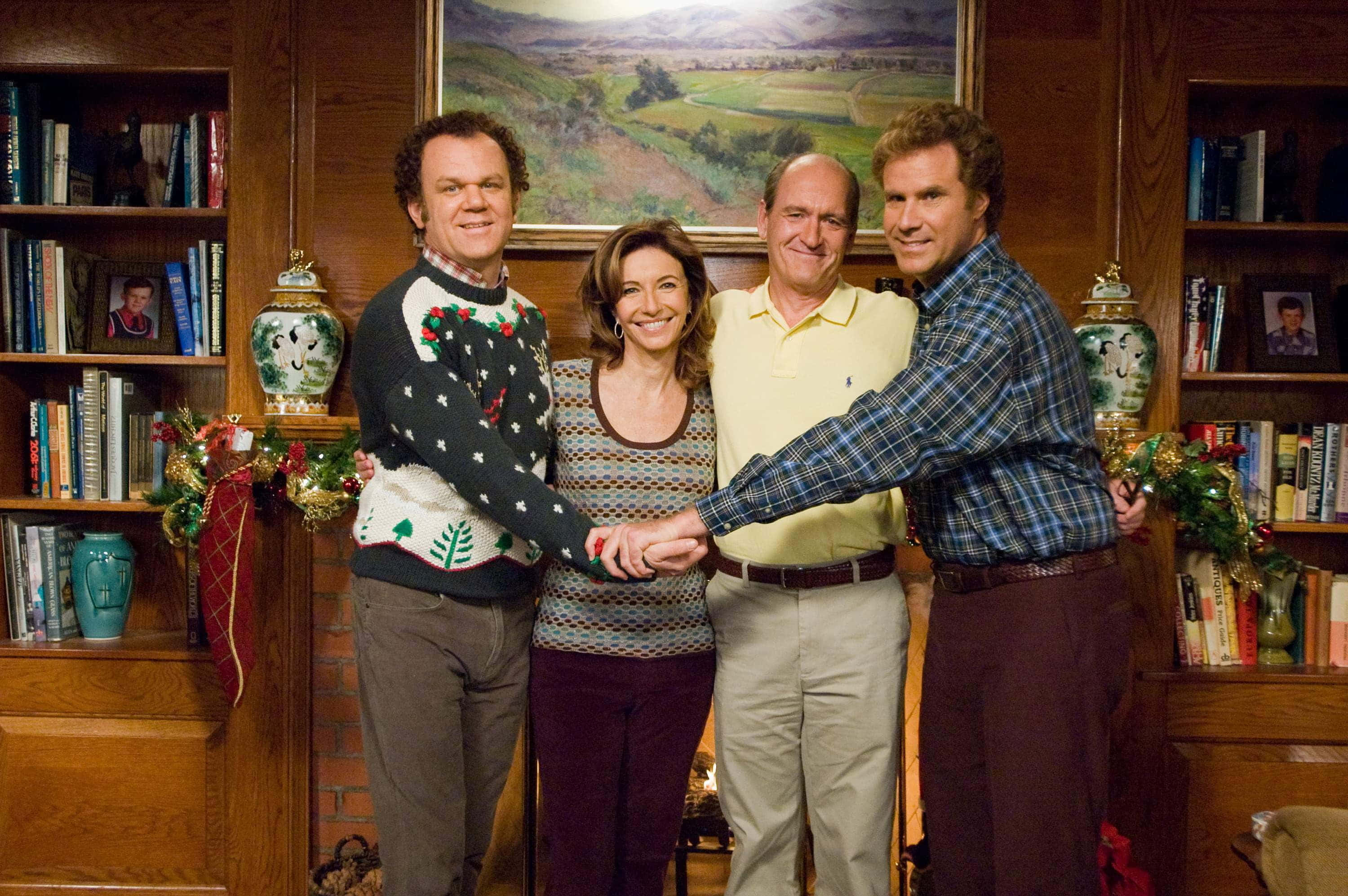 John C. Reilly 桌布 壁紙 — 四人在一個溫暖照明的木鑲板房間裡手牽手，進行節日聚會。