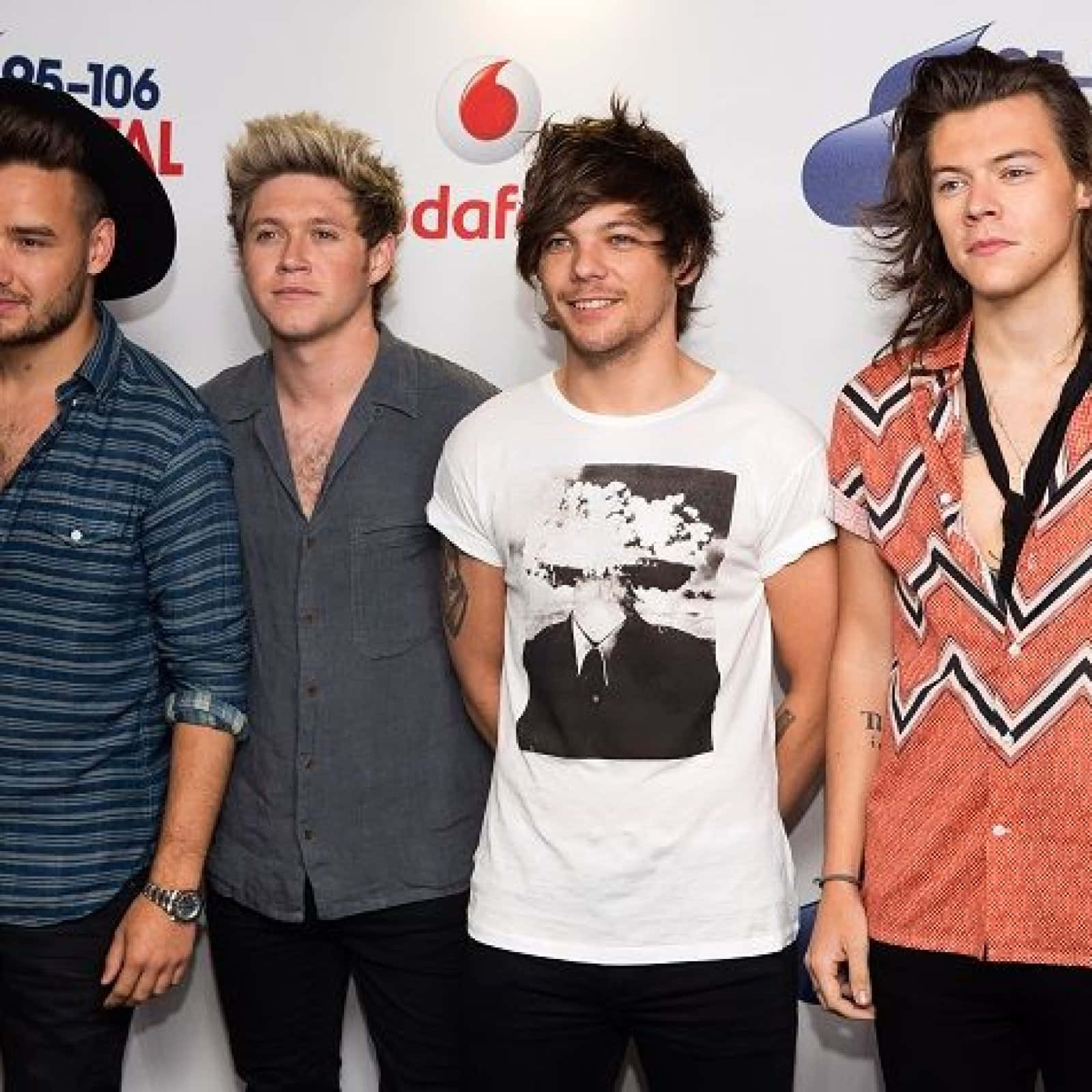 One Direction 桌布 壁紙 — 四位男音樂人在一個音樂頒獎活動中，於品牌背景前一起擺姿勢。