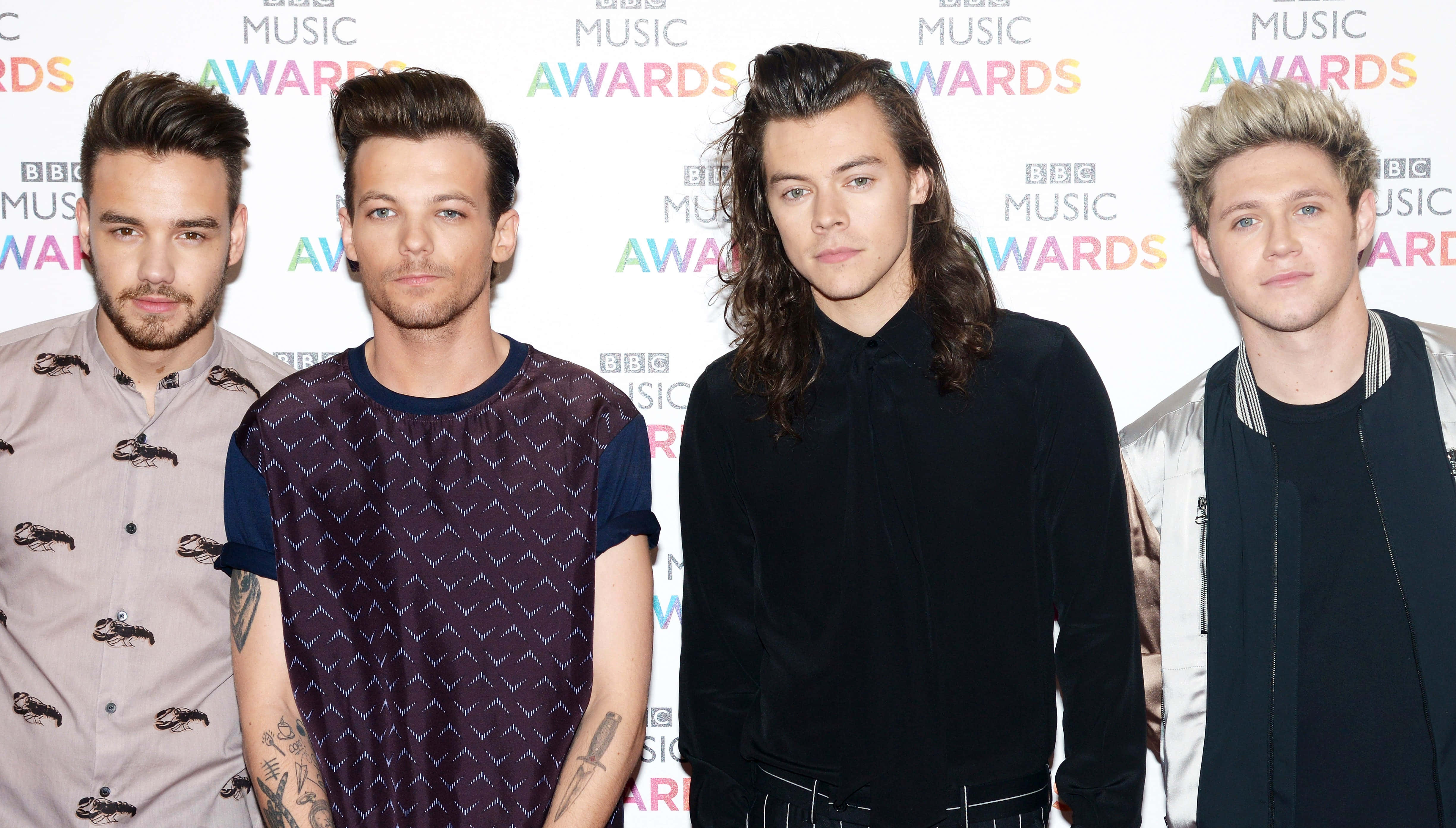 One Direction 桌布 壁紙 — 四位男音樂家在BBC音樂獎活動中，在品牌背景前正式擺姿勢。