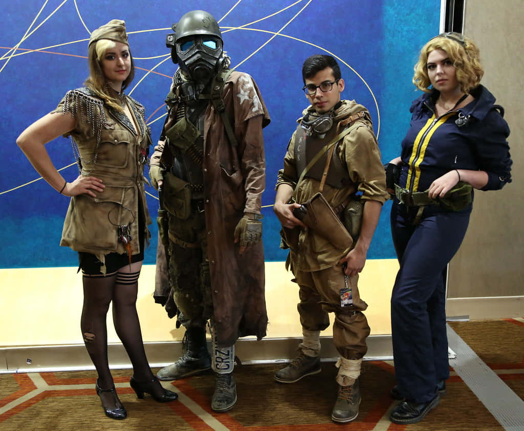 Fallout Characters 桌布 壁紙 — 四位穿著 Fallout 風格服裝的角色扮演者，在藍色幾何牆前自信地擺姿勢。
