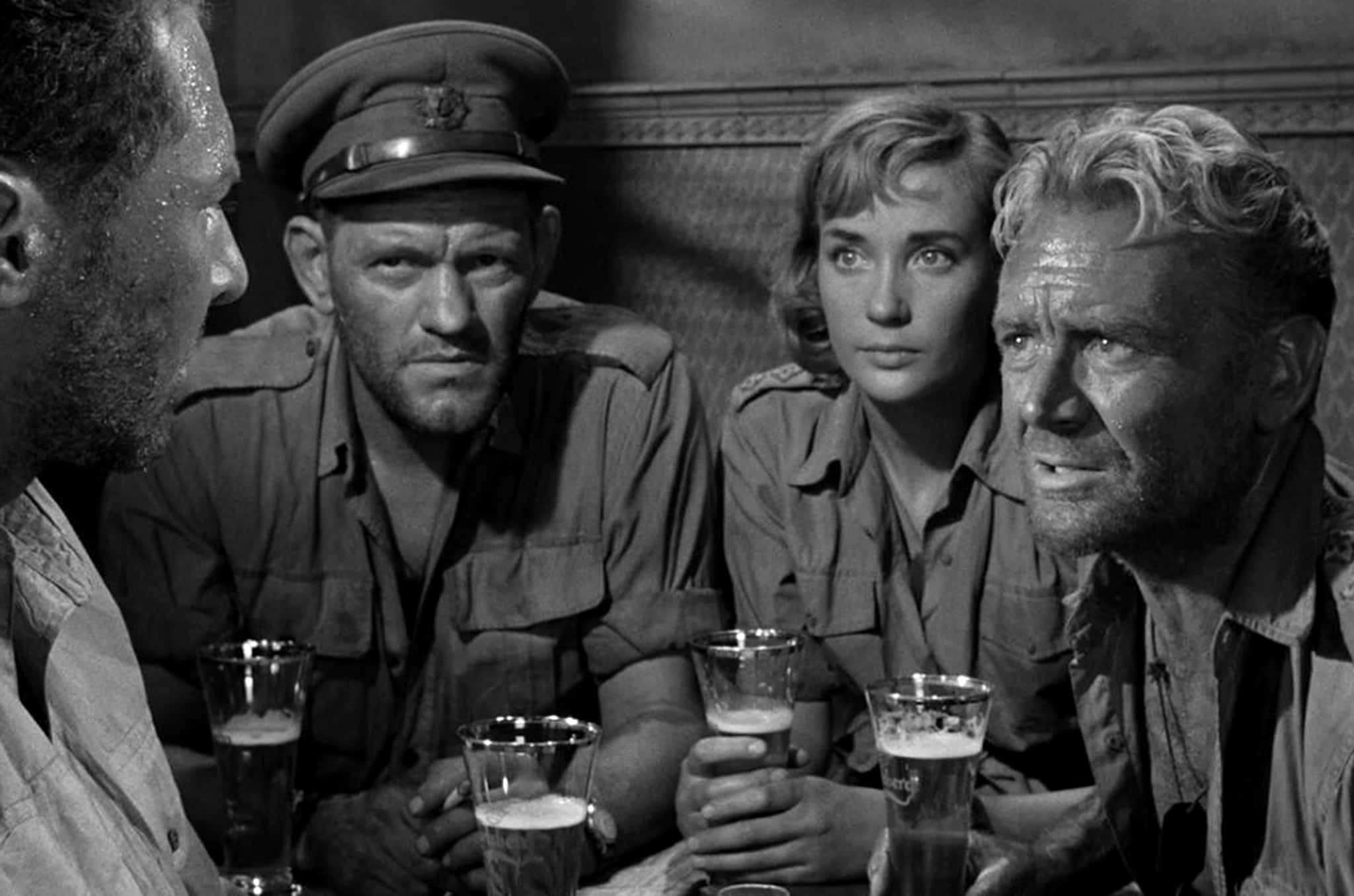Classic Movie 桌布 壁紙 — 四位身穿制服、疲憊不堪的士兵圍坐在一張放有啤酒杯的桌子旁，身處燈光昏暗的房間，臉上刻滿了疲憊與緊張。