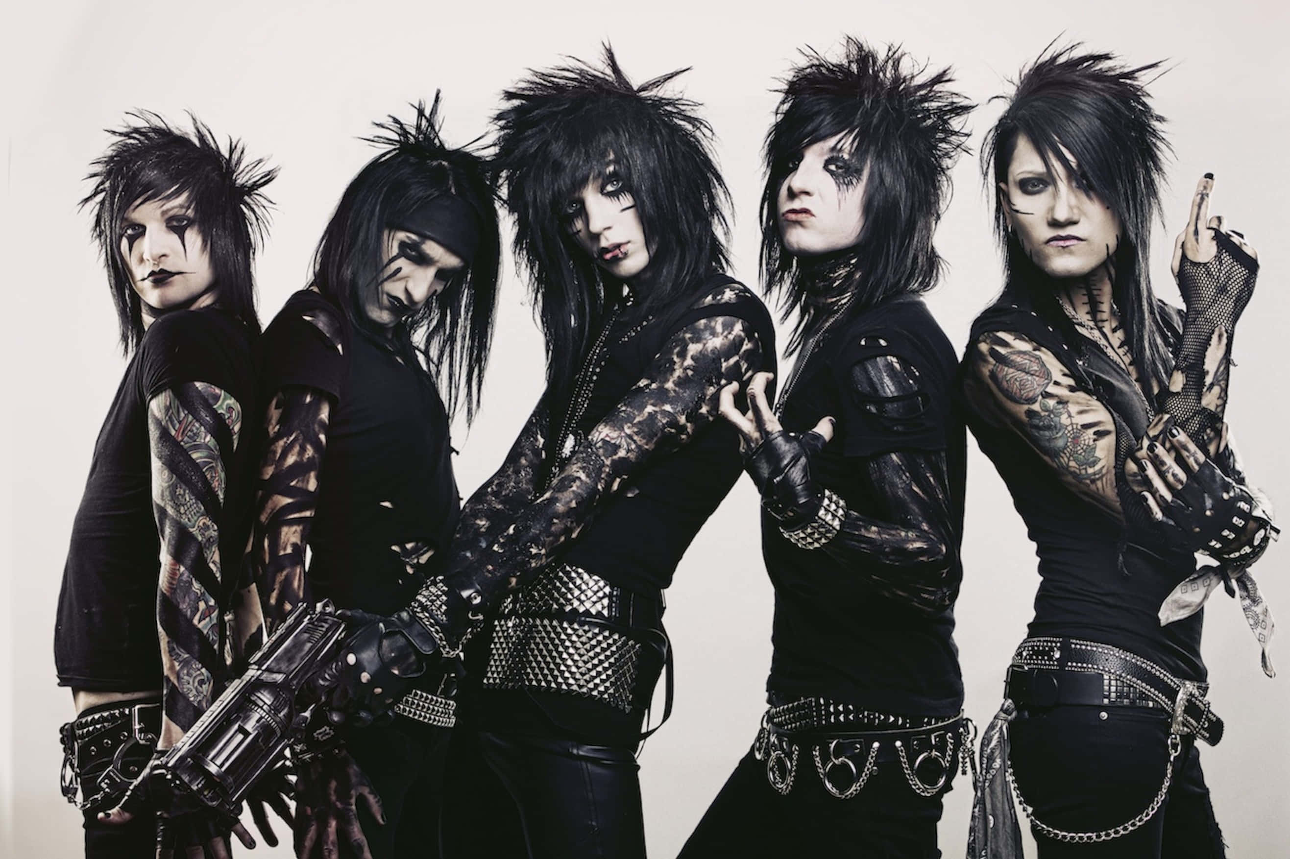 Black Veil Brides 桌布 壁紙 — 四位龐克搖滾樂手，擁有尖刺黑髮、紋身和鉚釘皮革裝備，在純色背景前強烈擺姿勢。