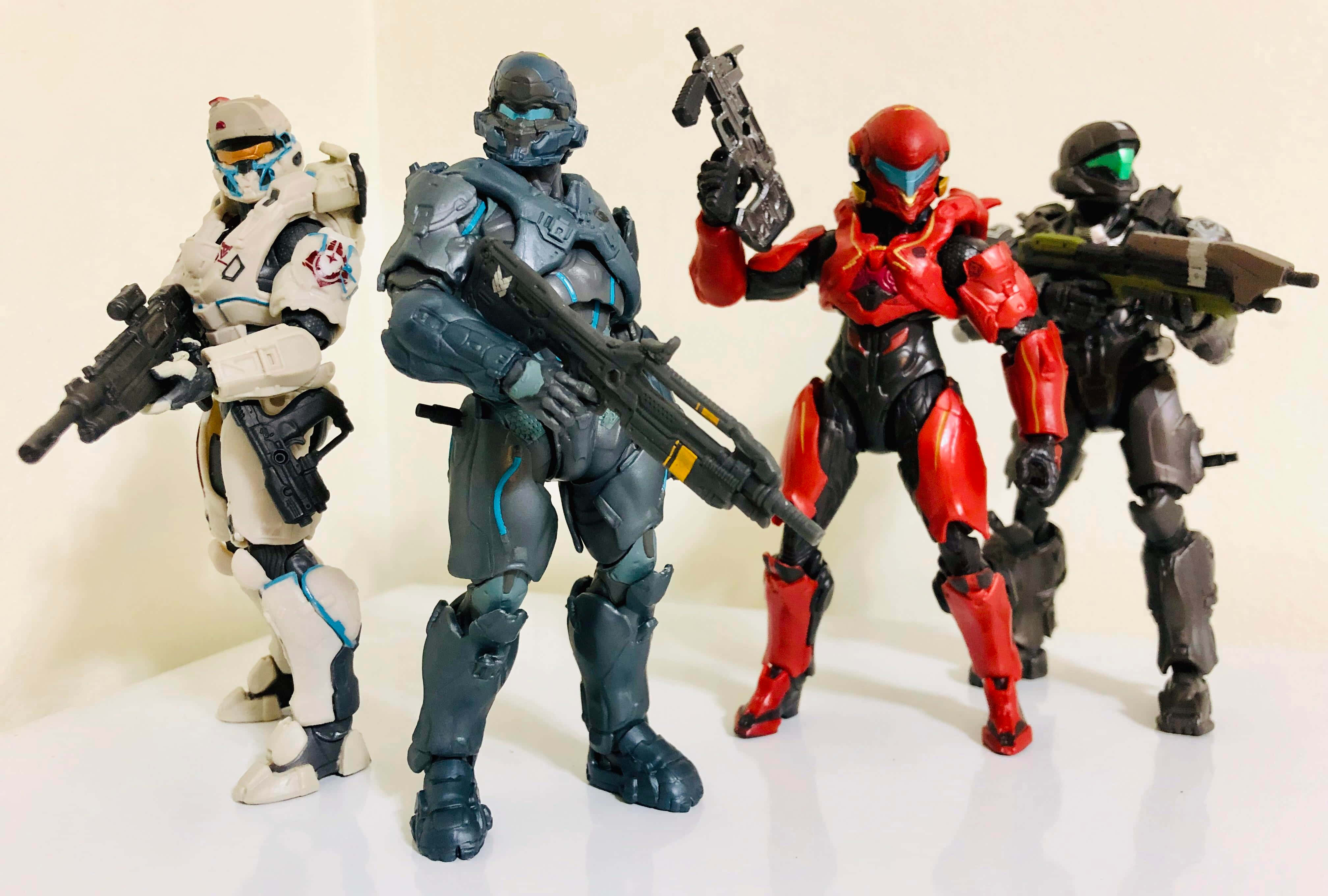 Fireteam Osiris 桌布 壁紙 — 四個Halo可動人偶身穿精細盔甲，手持武器，一字排開站在純白背景前。