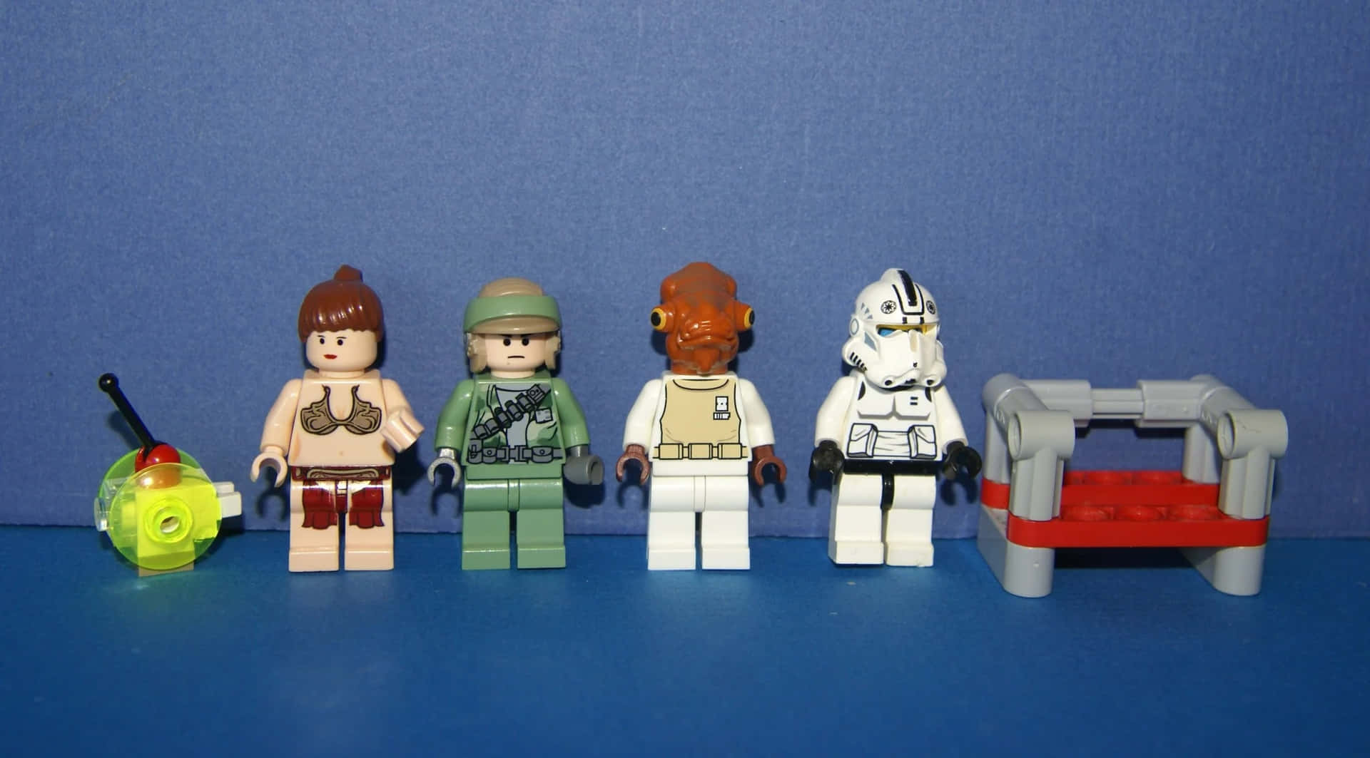 Admiral Ackbar 桌布 壁紙 — 四個LEGO Star Wars人仔和一個小長凳在純藍色背景前一字排開。