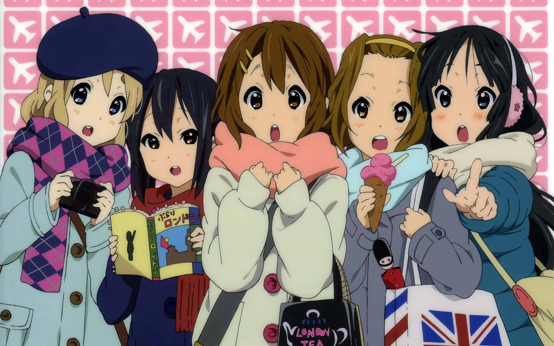 K-on 桌布 壁紙 — 四個動漫女孩穿著冬季外套和圍巾，在粉紅色飛機圖案背景前開心地擺姿勢。