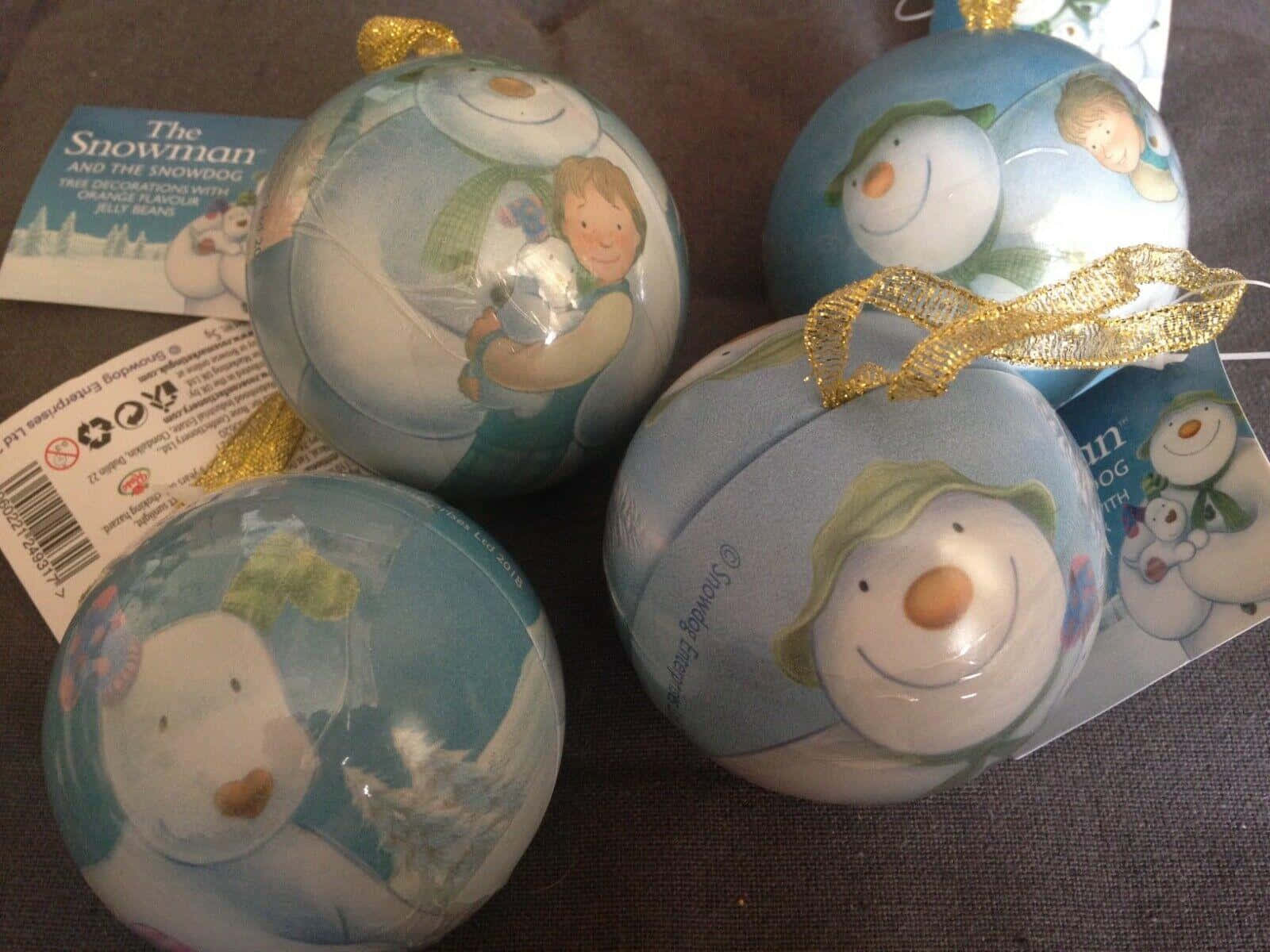 雪人 桌布 壁紙 — 四個插圖聖誕裝飾，包含雪人和男孩角色，藍色包裝配金色絲帶。