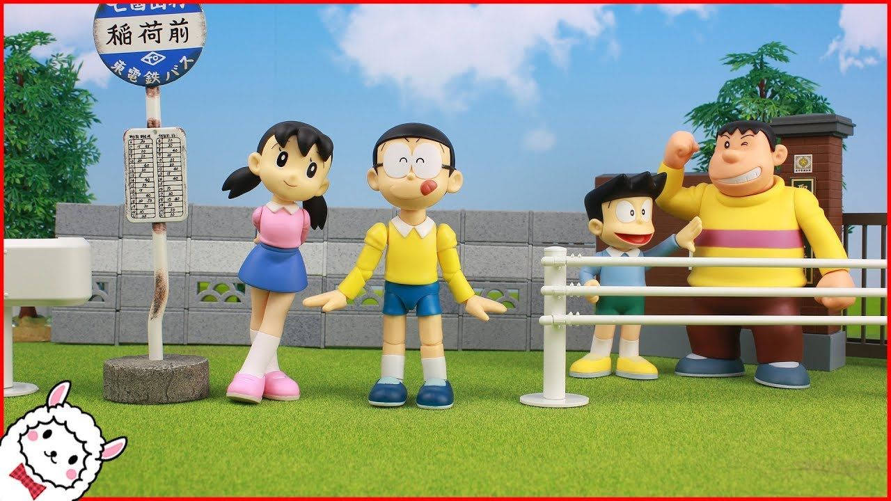 nobita shizuka love 桌布 壁紙 — 四個標誌性動漫角色並肩站在一個草地平台上，旁邊是火車站標誌，頭頂是明亮的藍天。