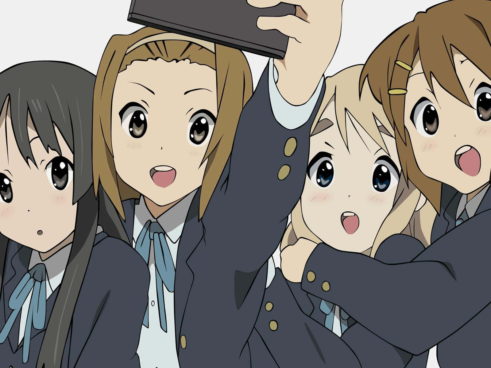 K-on 桌布 壁紙 — 四個穿著校服的動漫女孩開心地在平板電腦上自拍，她們的表情充滿興奮和友誼。