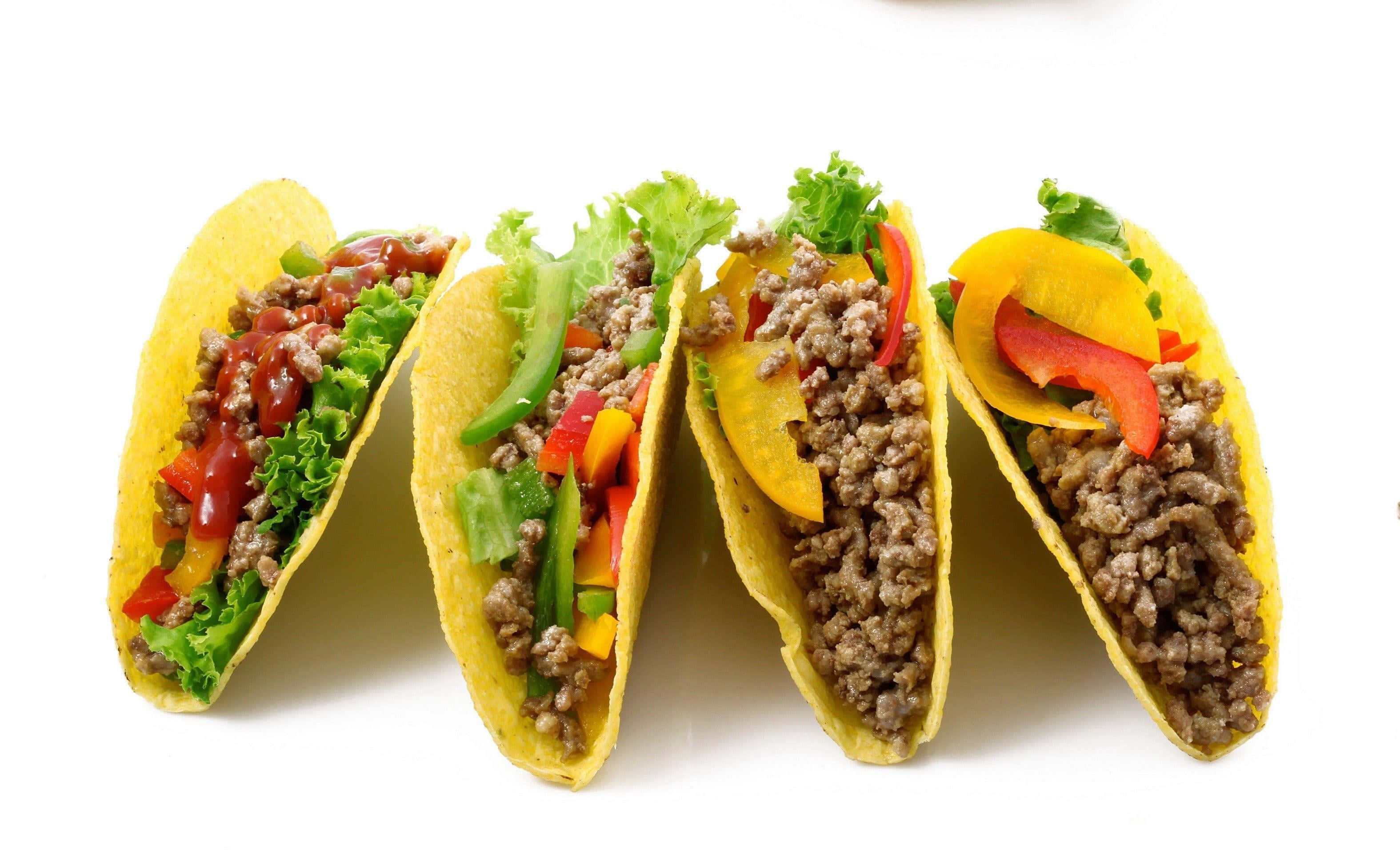 Taco 桌布 壁紙 — 四個色彩繽紛的墨西哥卷餅，內餡有調味肉、生菜、甜椒和醬汁，整齊排列在白色背景上。