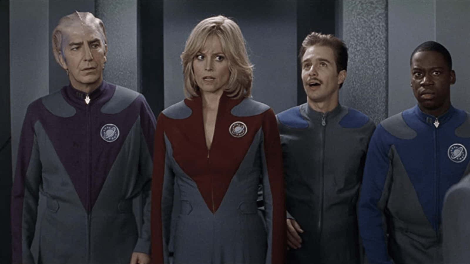 Galaxy Quest 桌布 壁紙 — 四名穿著未來風格制服嘅船員企喺燈光昏暗嘅太空船走廊，表情震驚。