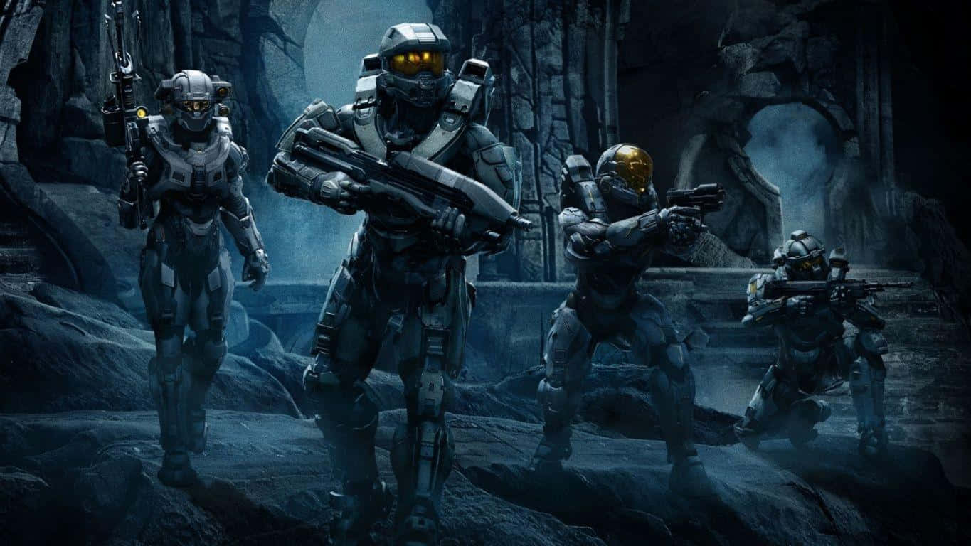 Halo Red Team 桌布 壁紙 — 四名裝甲士兵戴著發光面罩，穿過迷霧籠罩的廢墟，其中有古老的石拱門和岩石地形。