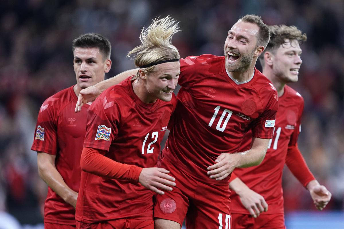 Football Players 桌布 壁紙 — 四名身穿紅色球衣的丹麥足球員在球場上瘋狂慶祝入球，充滿喜悅與活力。