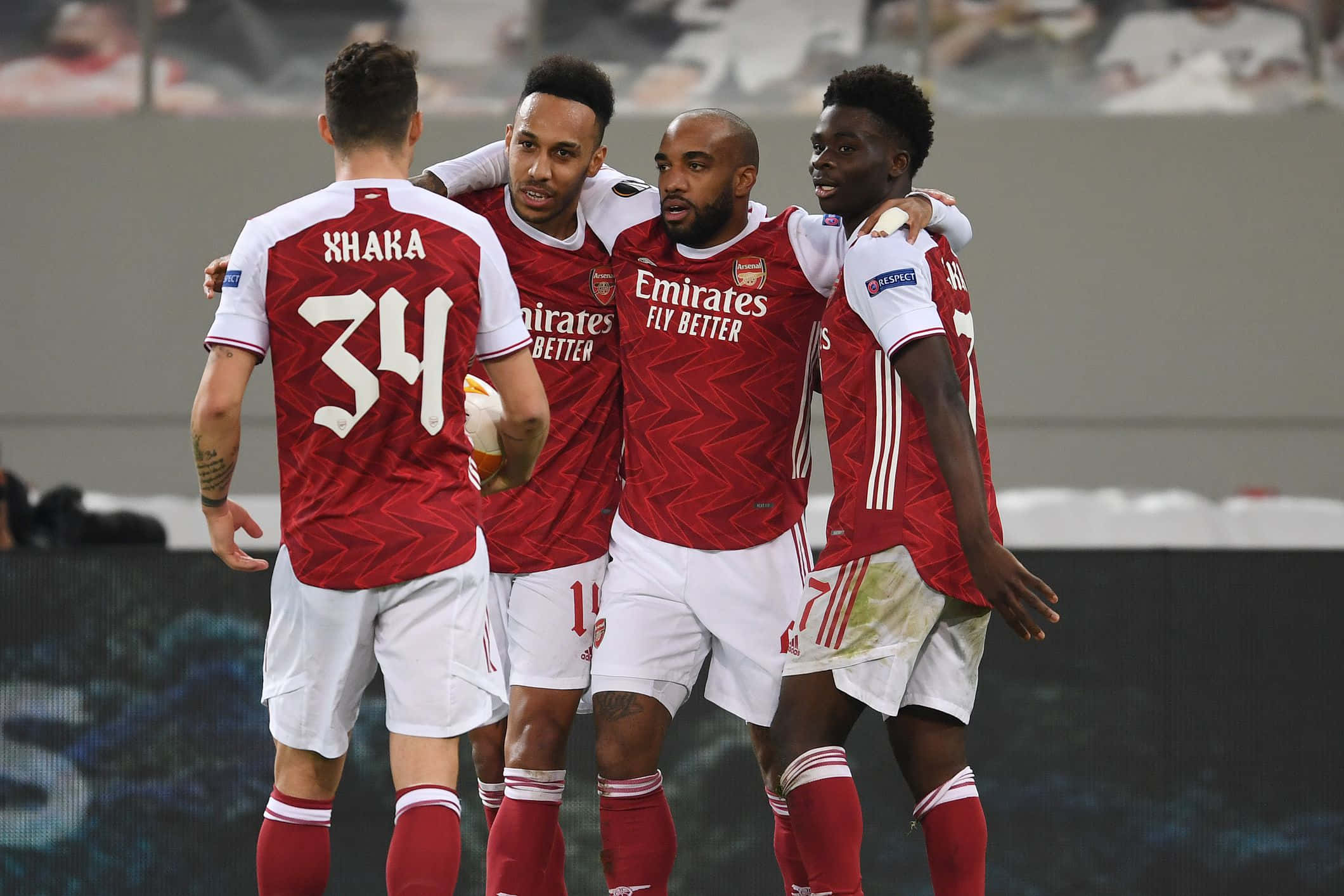Arsenal 桌布 壁紙 — 四名身穿紅色球衣的阿仙奴足球員在球場上互相擁抱慶祝入球。