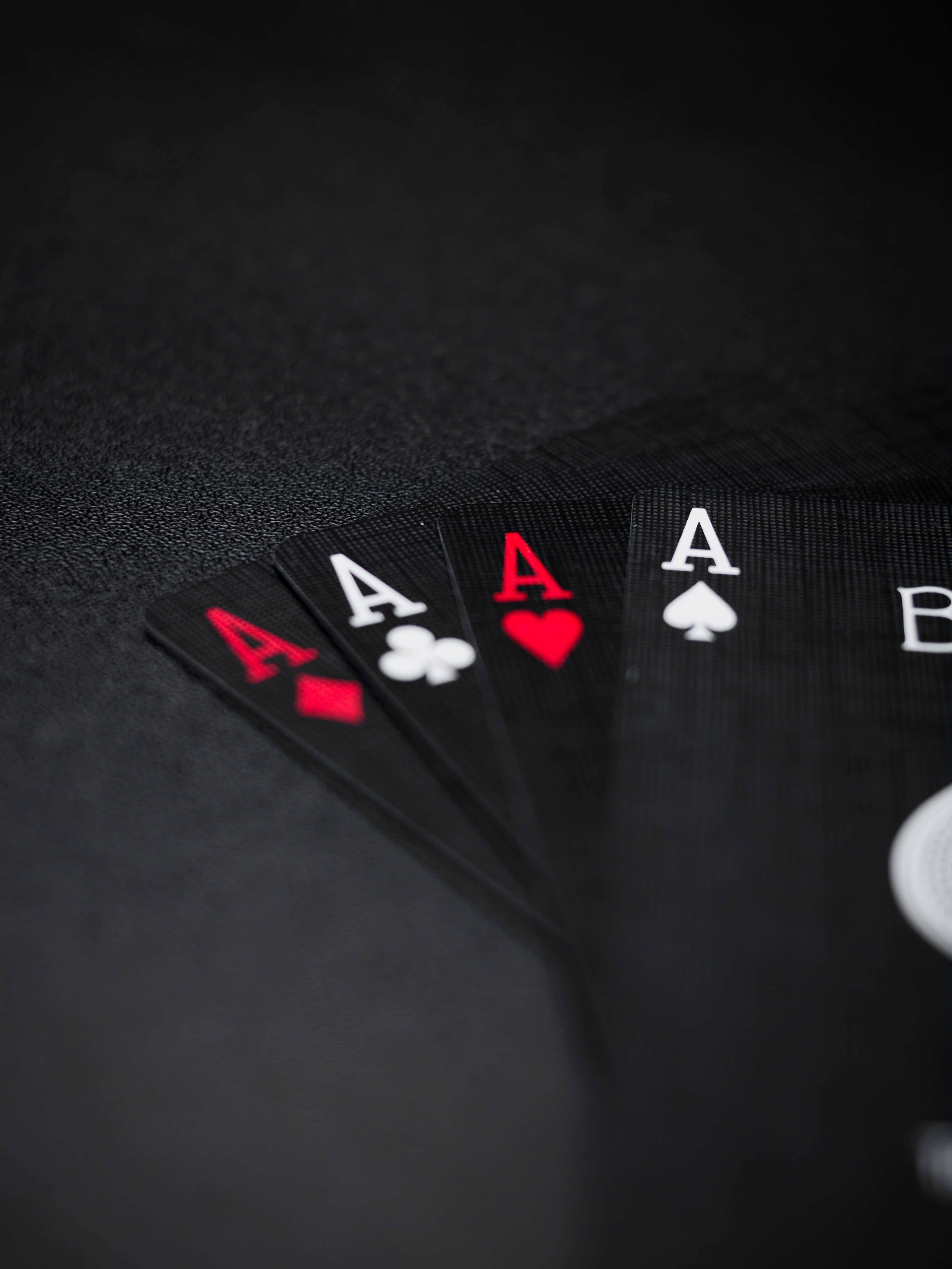 Card Games 桌布 壁紙 — 四張啤牌Ace以扇形排列在深色紋理表面上，景深較淺。