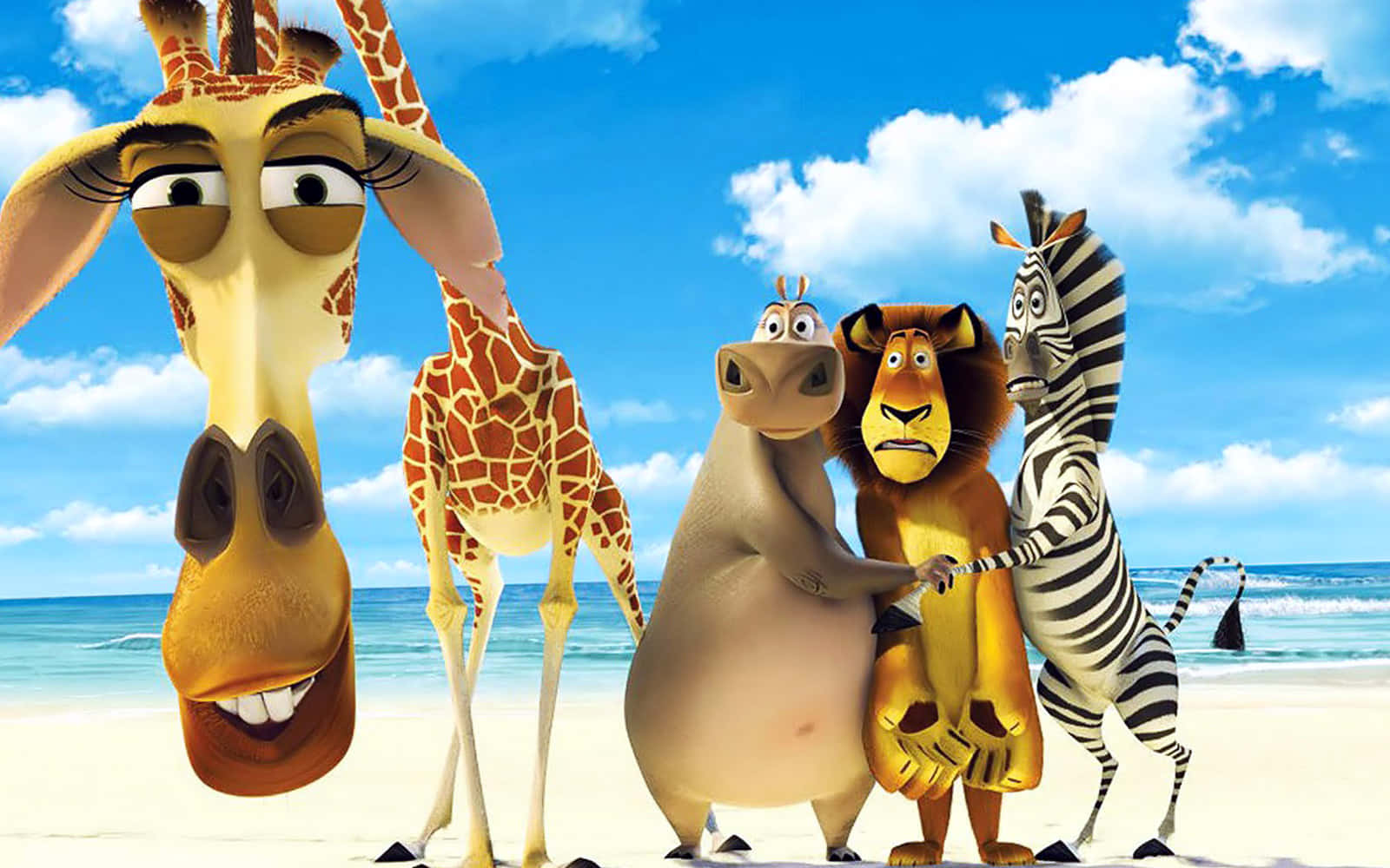 Animated Desktop 桌布 壁紙 — 四隻動畫動物：長頸鹿、河馬、獅子和斑馬，一起站在陽光明媚的海灘上，身後是海浪和藍天。