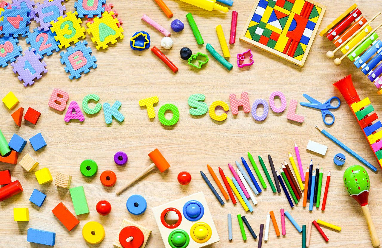 色彩繽紛的學校用品和玩具排列在木質表面上，拼出 back to school。