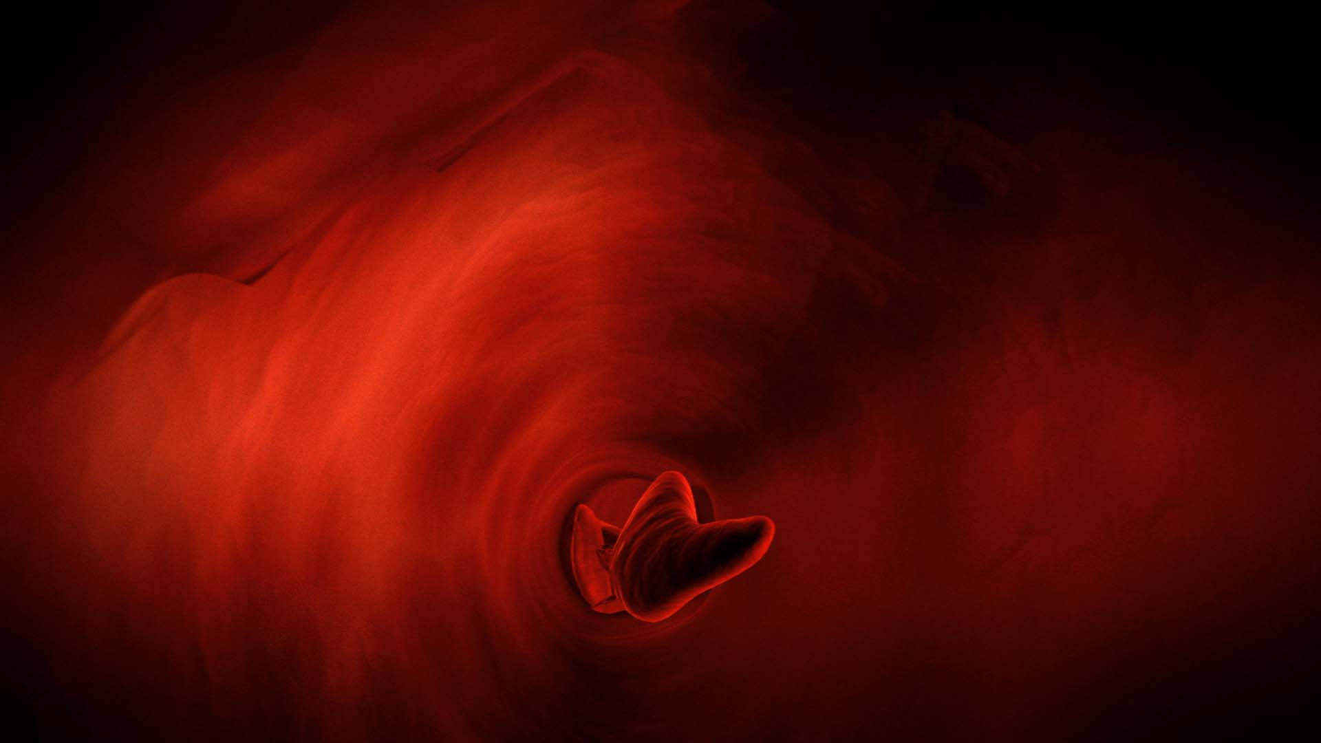 旋轉宇宙渦流中心的一顆發光紅心。