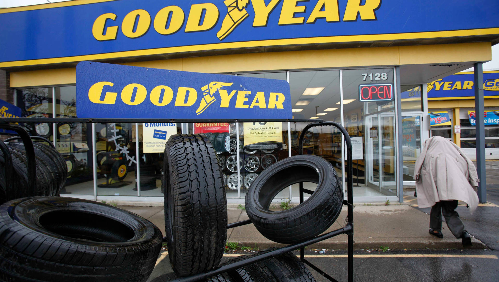Goodyear輪胎店，輪胎陳列在外面，有人在雨中走過。