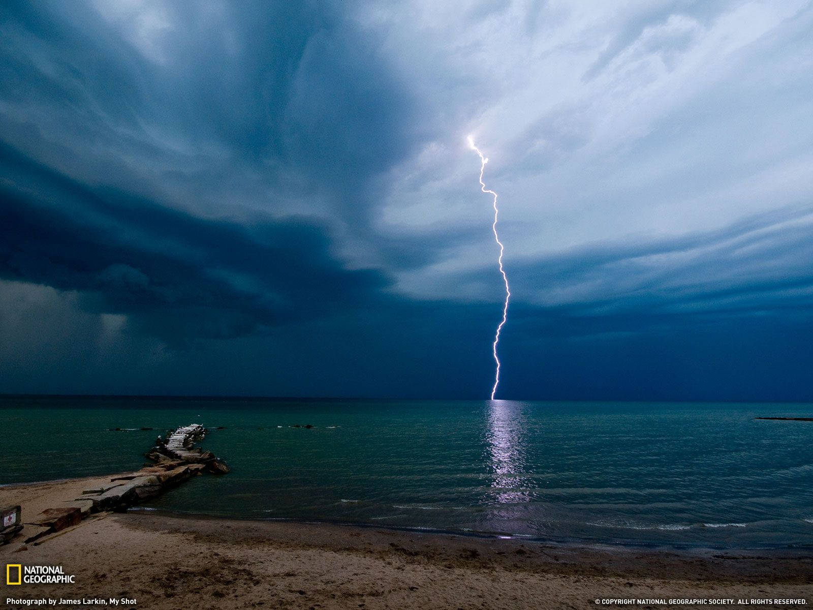 暴風雨之夜，閃電擊中海灘上的海洋。