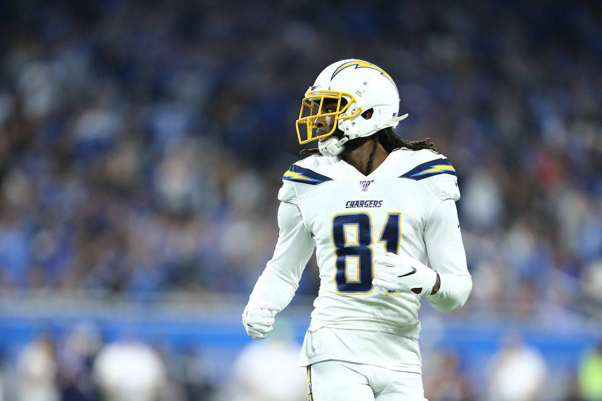 身穿Chargers球衣的美式足球員在夜間球場上行走。