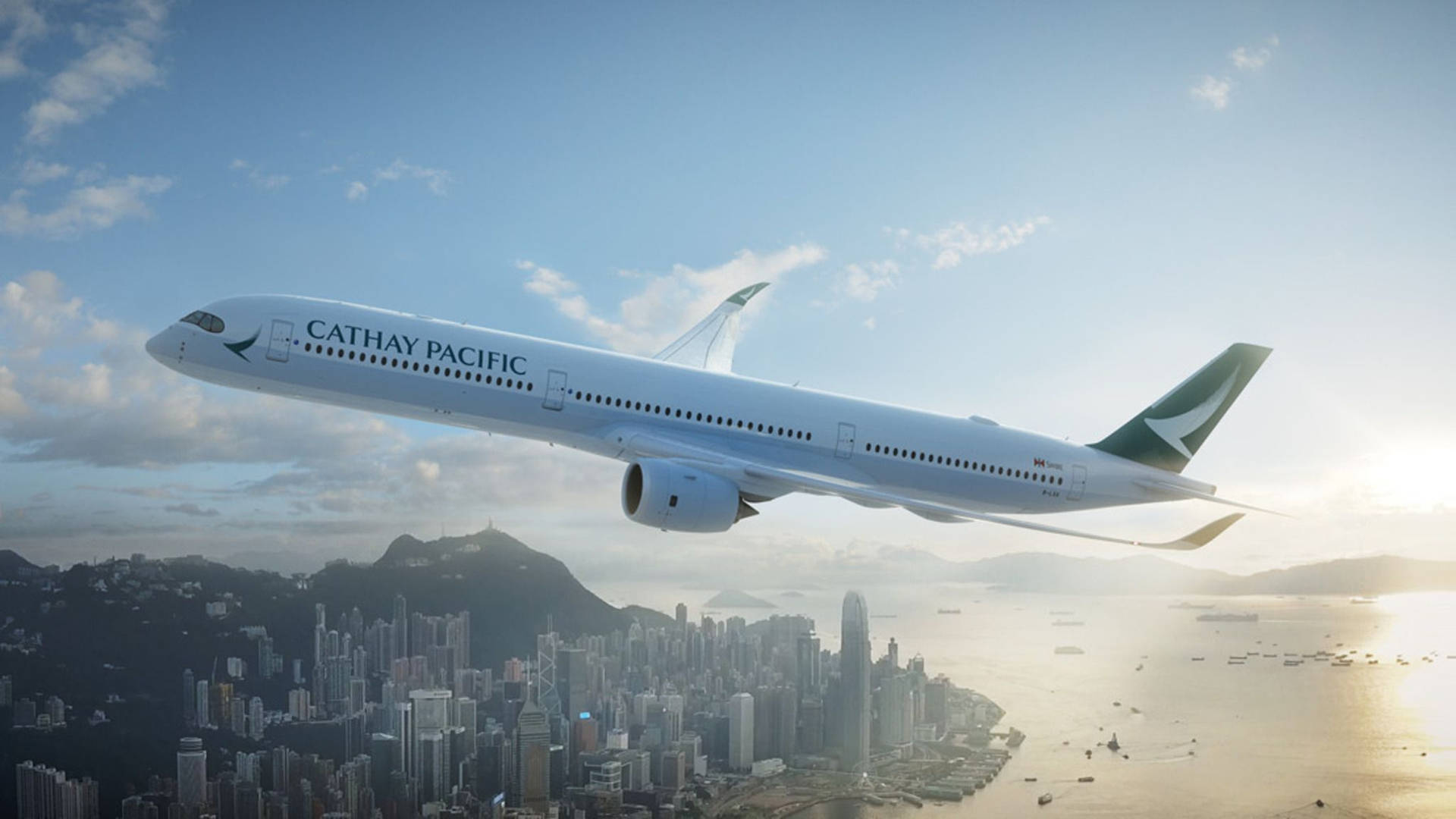 國泰航空飛機在日落時分飛越香港城市景觀。