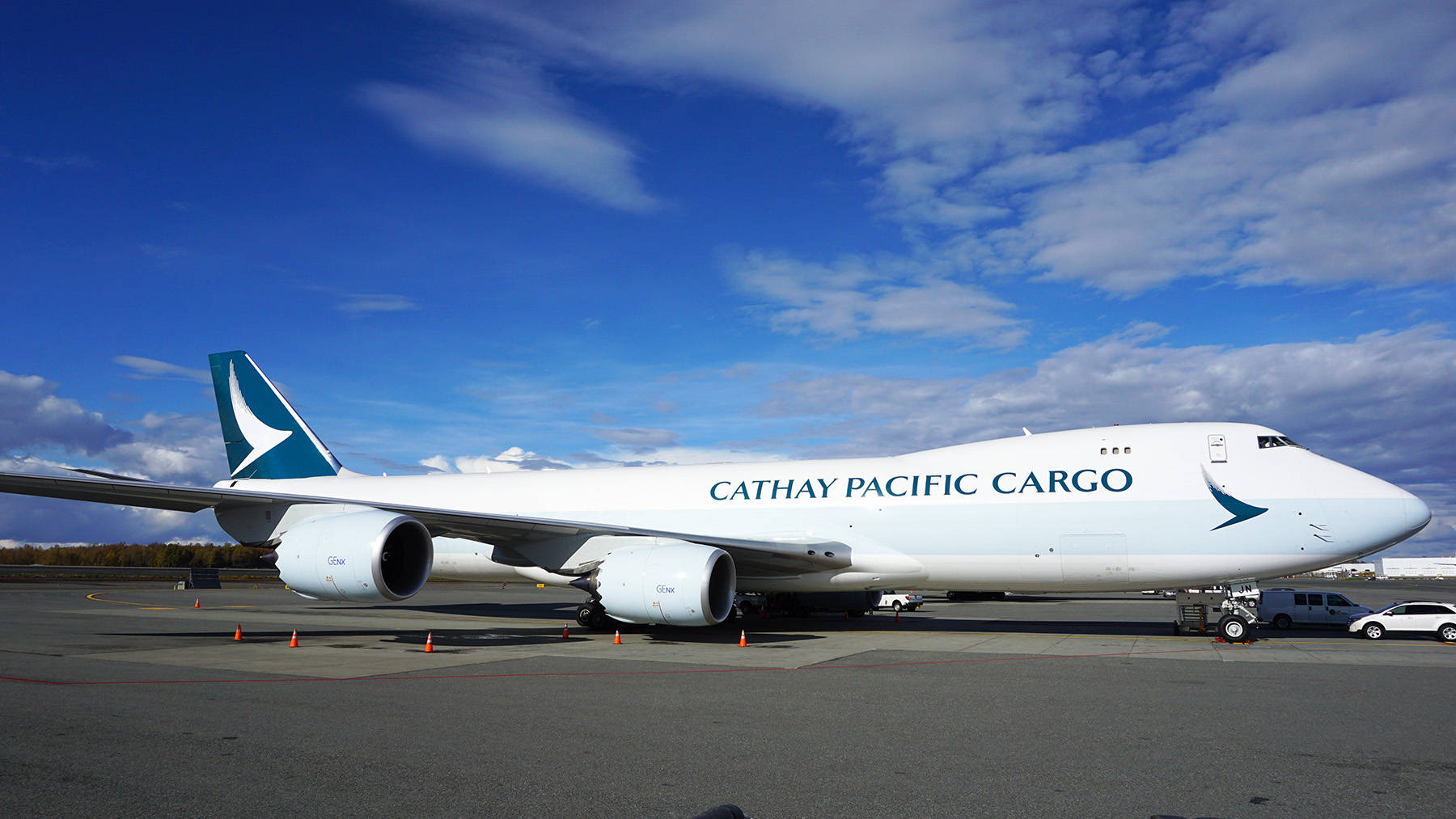 國泰航空貨運波音747在機場停機坪上，藍天白雲