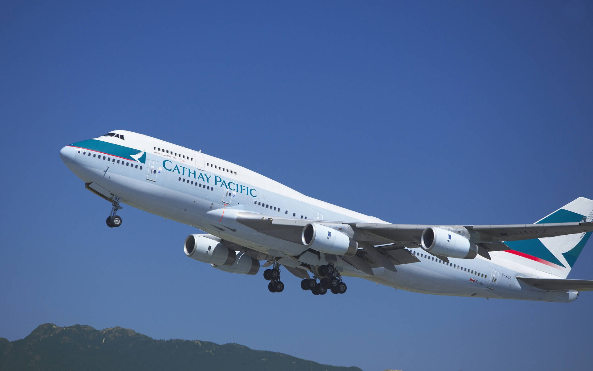 國泰航空飛機在晴朗的日子低飛越過山脈。