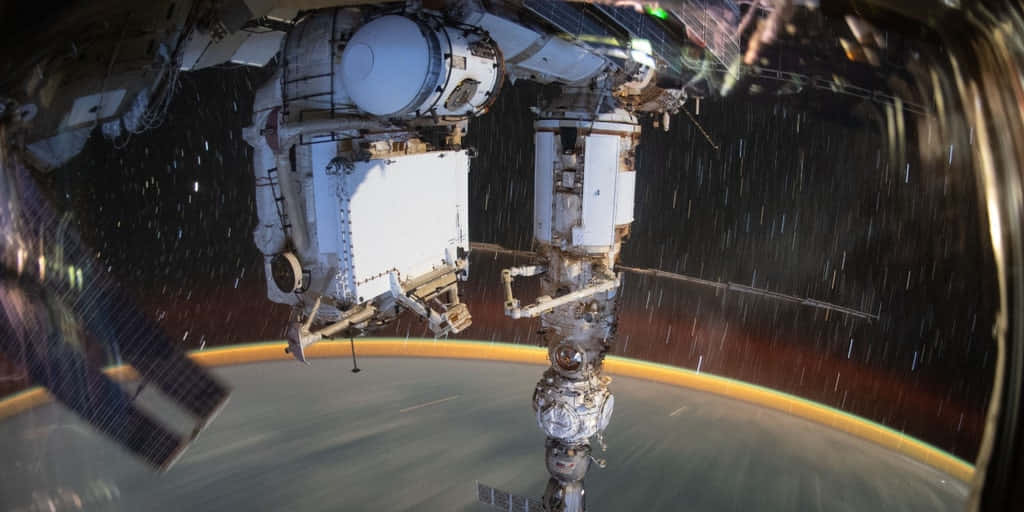 International Space Station 桌布 壁紙 — 國際太空站漂浮在地球上空的詳細視圖，背景是彎曲的地平線和星域。