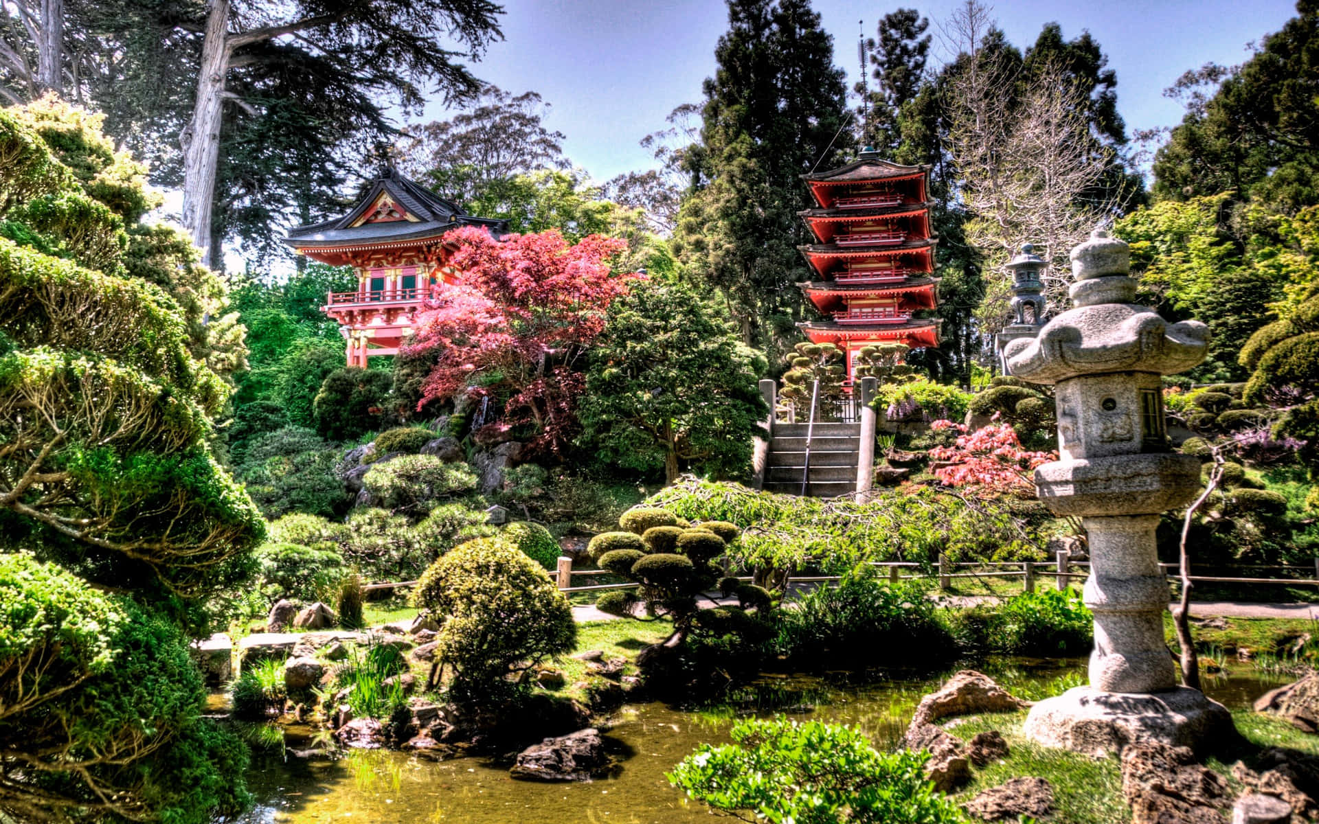 日本庭園，有寶塔、石燈籠和池塘附近盛開的樹木