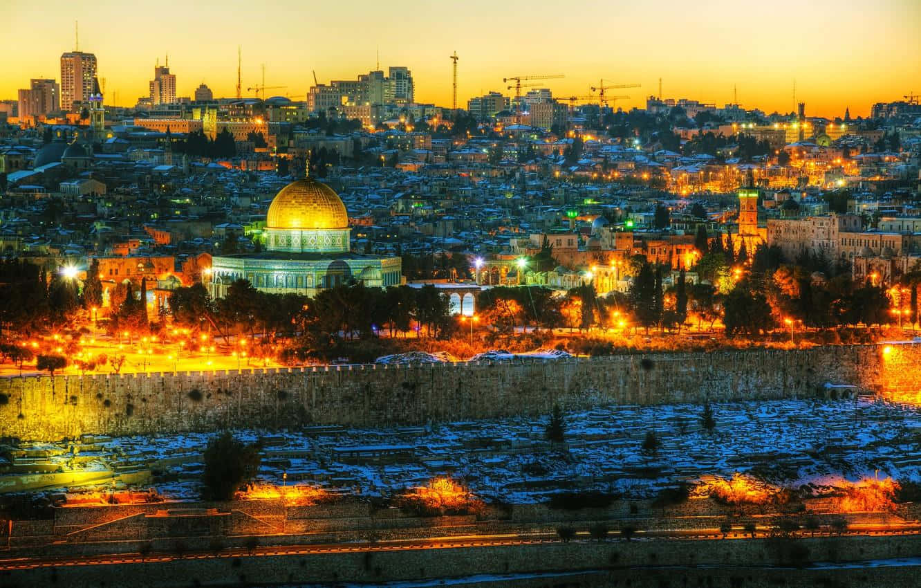 Israel 桌布 壁紙 — 圓頂清真寺的金色圓頂在古老的石牆上閃耀，城市燈火點亮了暮色天際線。
