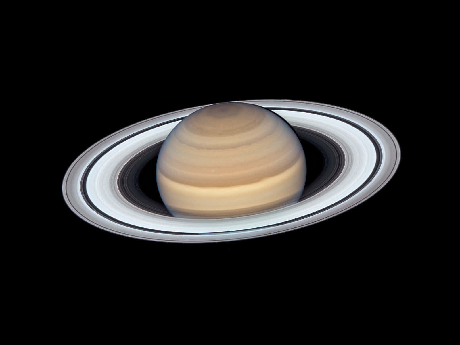 土星 桌布 壁紙 — 土星及其標誌性光環在太空的漆黑中柔和發光，構成一幅驚人的天體肖像。