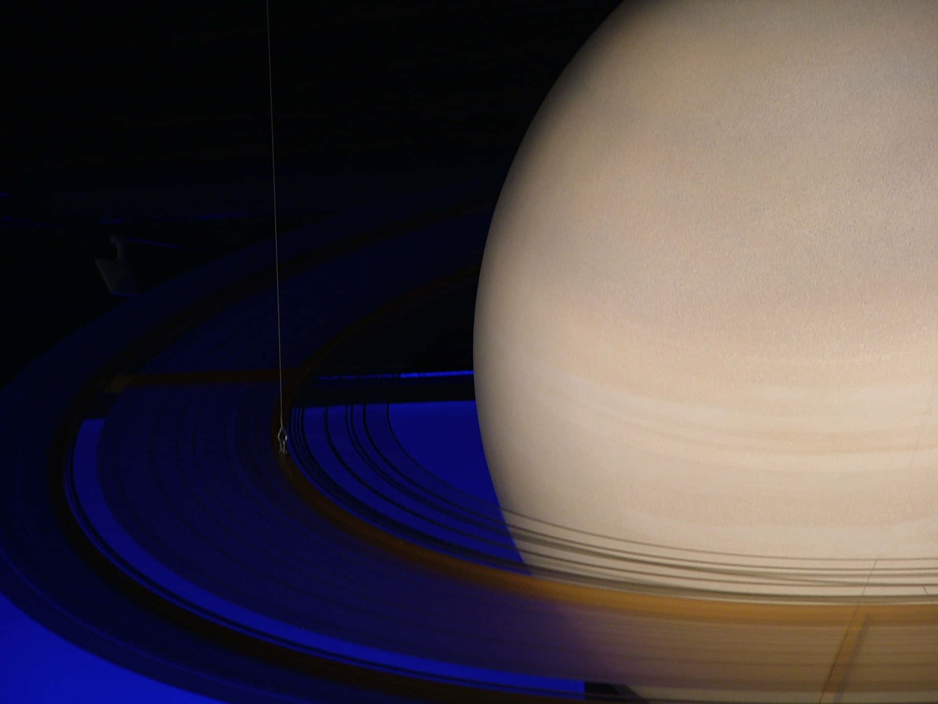 土星及其標誌性光環在黑暗太空背景下發出深藍色光芒。