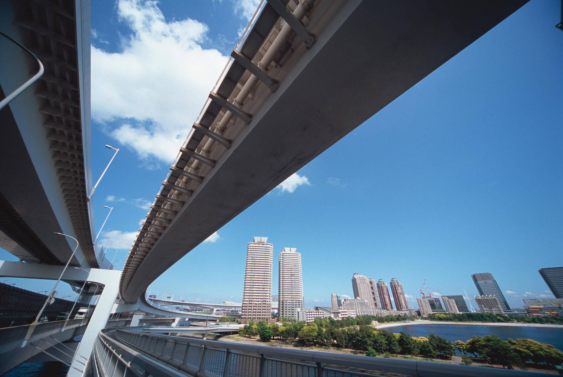 城市景觀，曲線橋樑與摩天大樓在清澈藍天下。