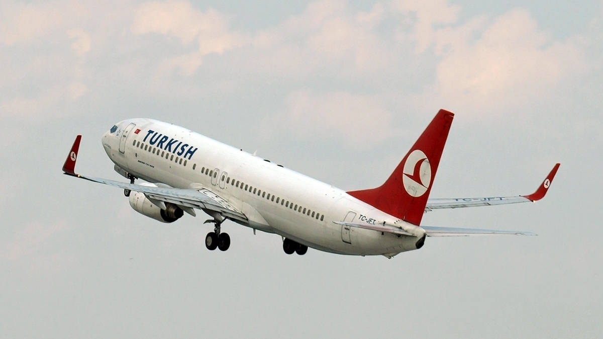 土耳其航空噴射機收起起落架在多雲天空中上升