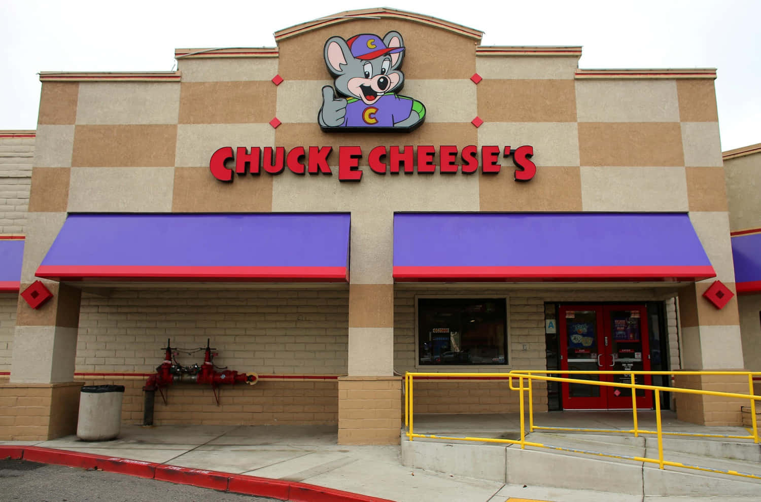 Chuck E Cheese's 餐廳，有卡通老鼠吉祥物和紫色遮陽篷。