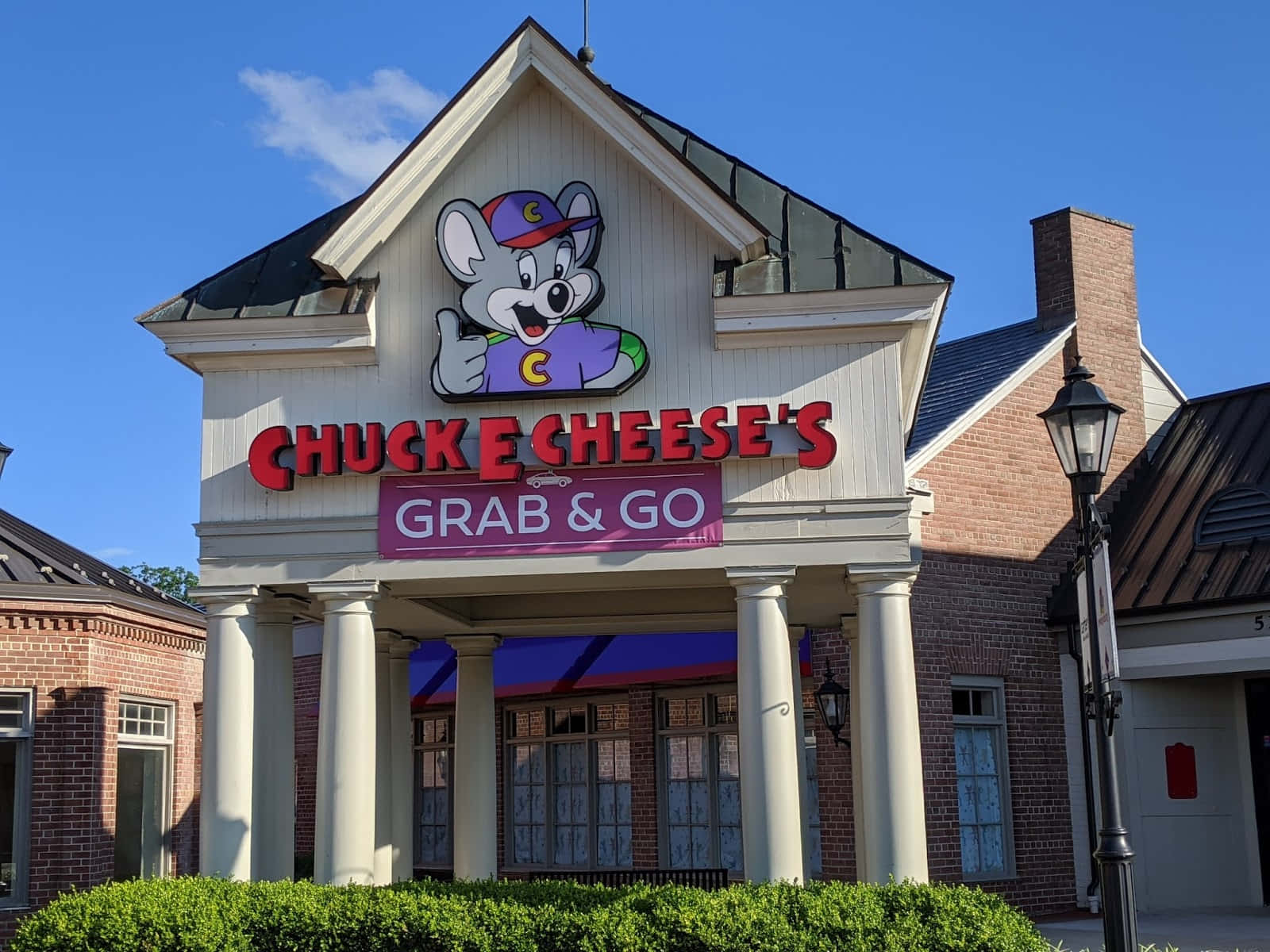 Chuck E Cheese's餐廳，卡通老鼠吉祥物和即取即走標誌。
