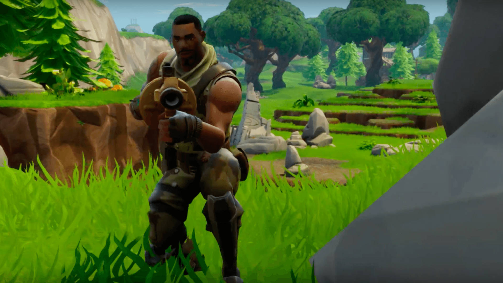 Fortnite角色蹲在草地上，在岩石和樹木附近手持武器