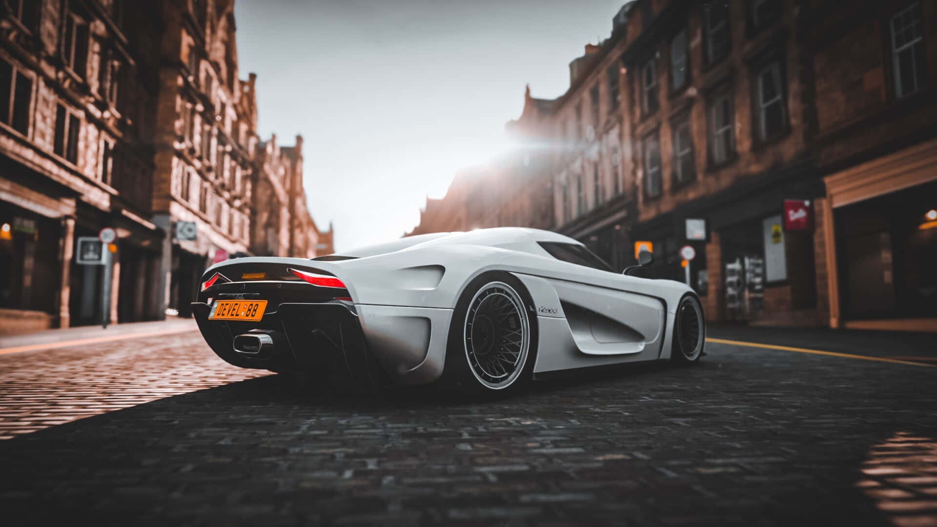日落時白色Koenigsegg Jesko超跑停在鵝卵石街道上。