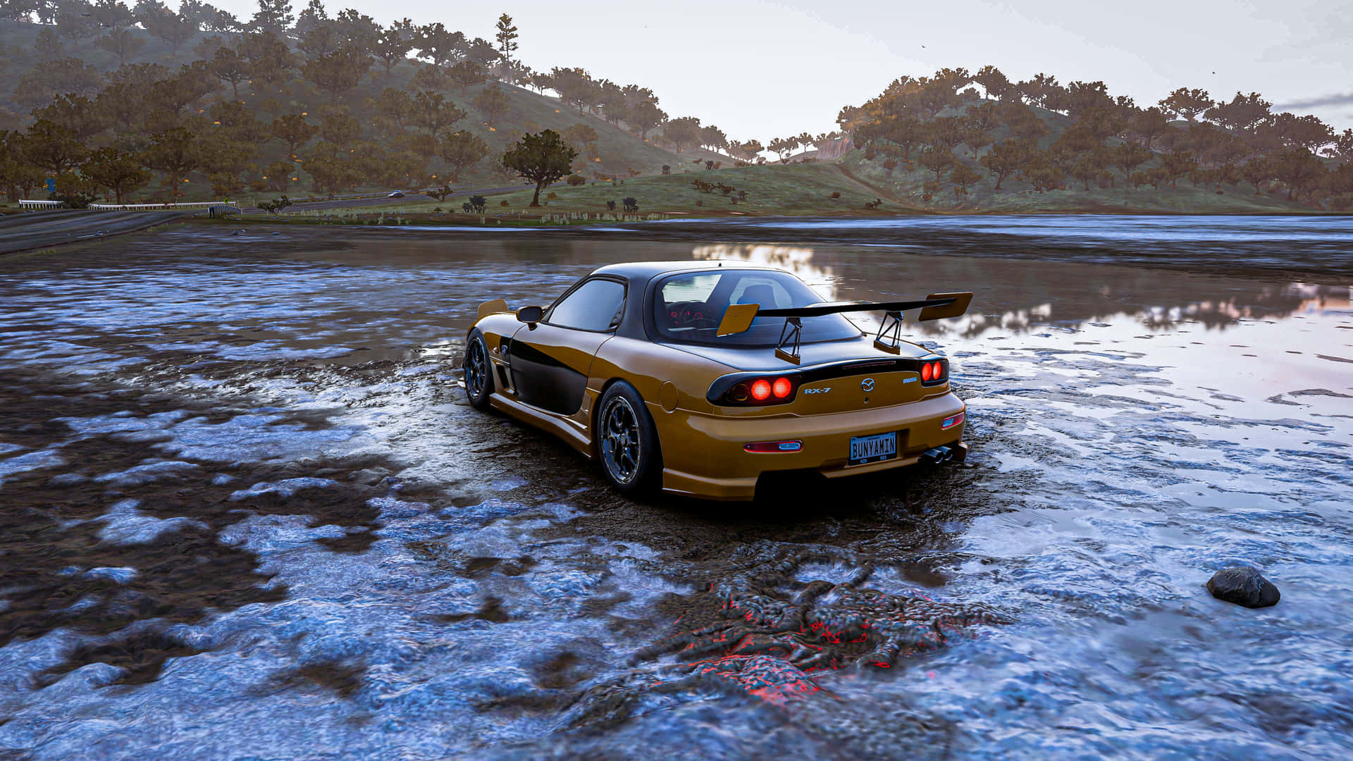 金色跑車在黃昏時駛過淺水，背景有樹木和丘陵。
