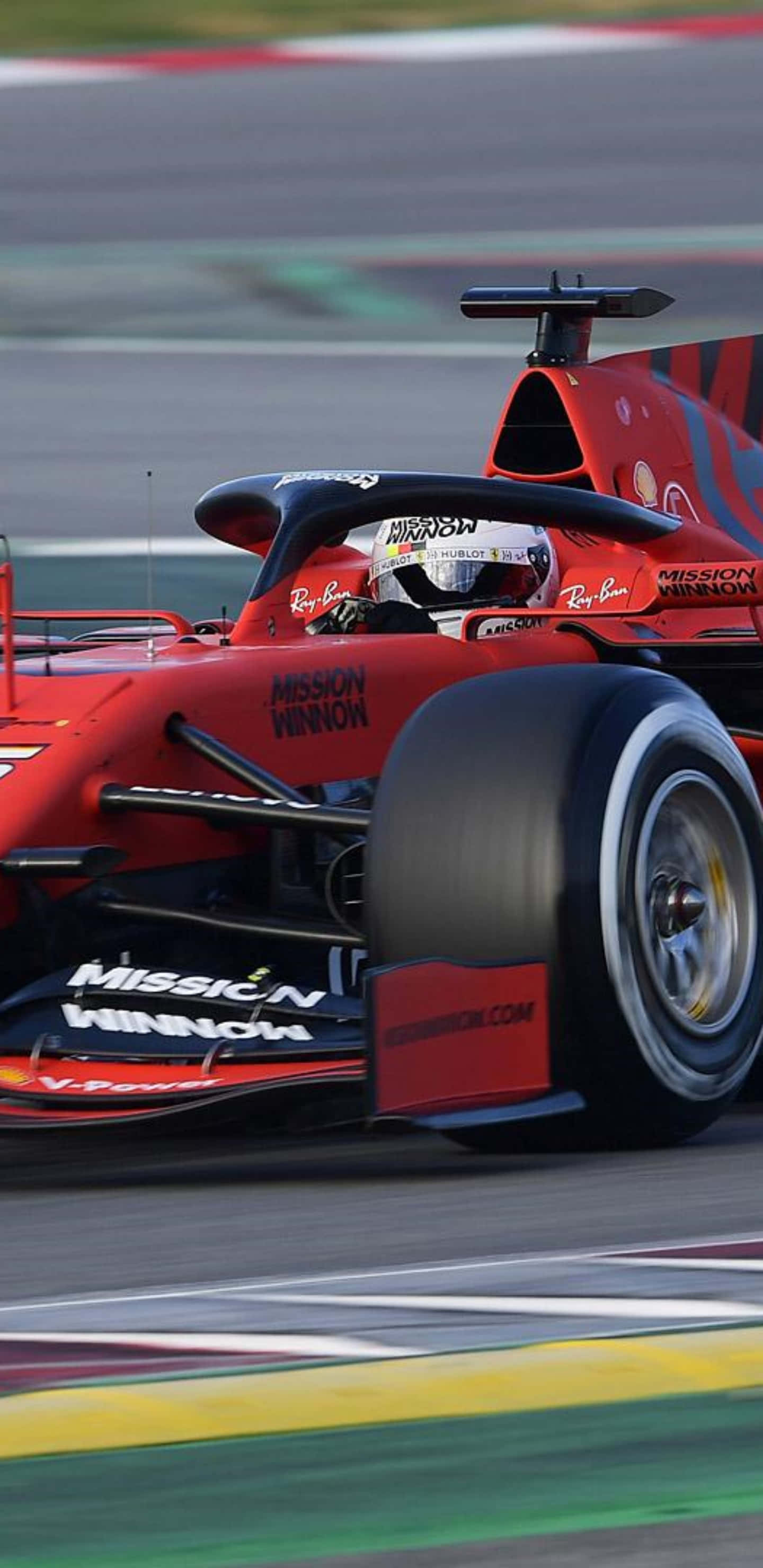 在 Google Pixel 3XL 上暢玩 F1 2019，享受流暢線上體驗 壁紙 — 一輛紅色一級方程式賽車在賽道上疾馳，帶有動態模糊和鮮明的賽道標記。