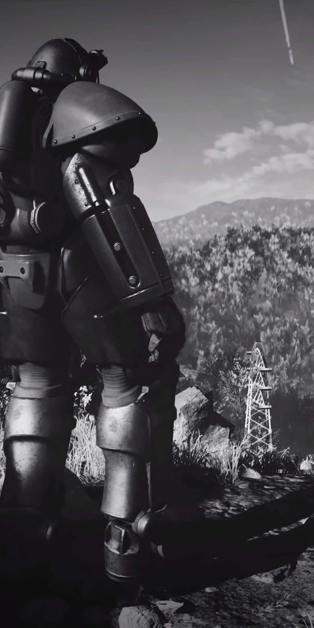在 Google Pixel 3 上享受 Fallout 76 的最新版本 壁紙 — 一個高聳的裝甲人物以單色調矗立在崎嶇的山景中，遠處有一座輸電塔。