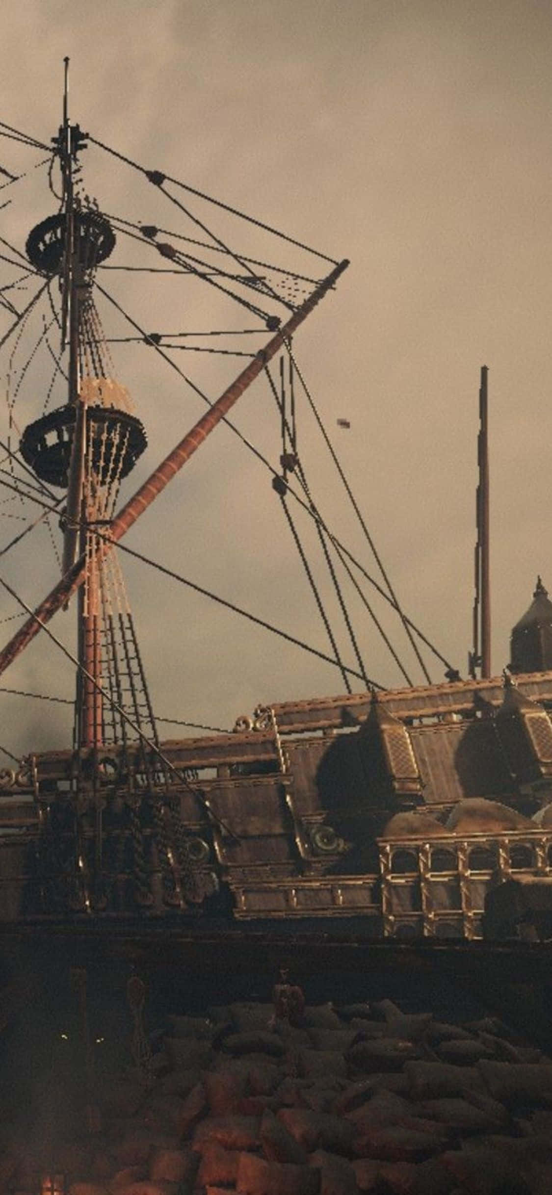 在《Greedfall》中開啟全新冒險 壁紙 — 一艘歷經風霜的海盜船的桅杆和索具在朦朧的天空和下方的岩石中若隱若現。