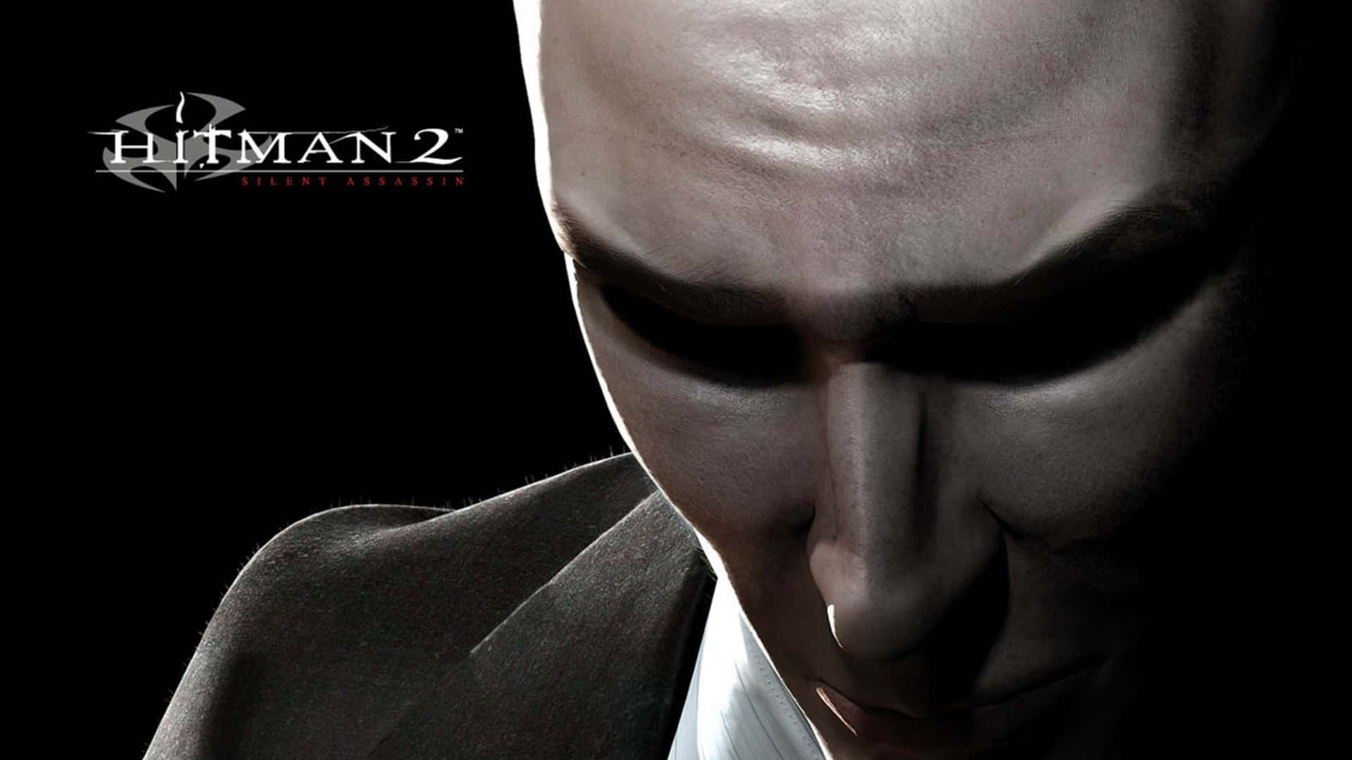 在 HD Hitman 2 中與時間賽跑 壁紙 — 《Hitman 2 Silent Assassin》中特工47的頭部特寫，帶有強烈陰影的臉龐和西裝，背景為黑色。