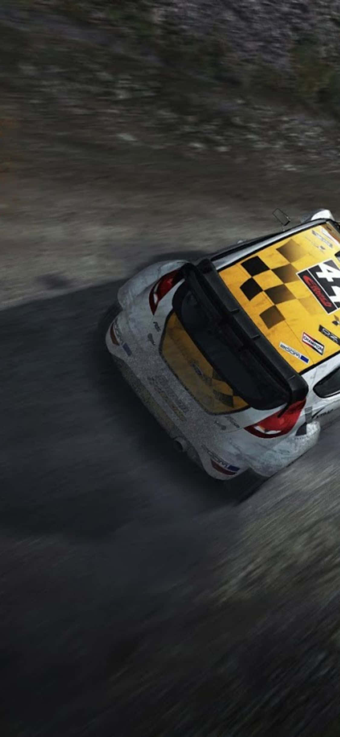 在 iPhone X Dirt Rally 中掌控賽車 壁紙 — 一輛帶有黃色棋盤格車頂的拉力賽車從俯視角度在泥濘的森林賽道上飛馳。