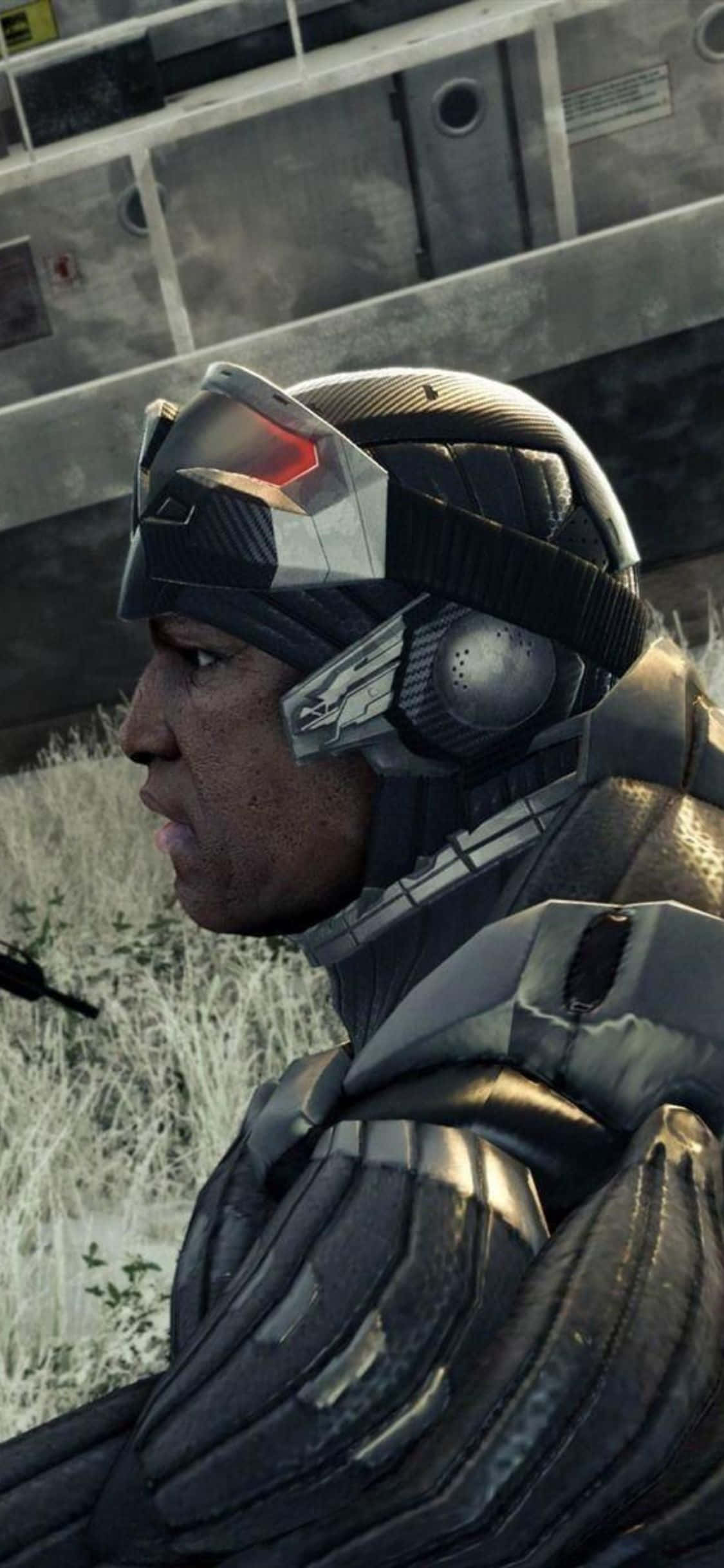 在 iPhone X 上探索 Crysis 3 的未來世界！ 壁紙 — 一名身穿未來黑色裝甲、配備紅色發光面罩的士兵，站在粗糙的工業環境中。