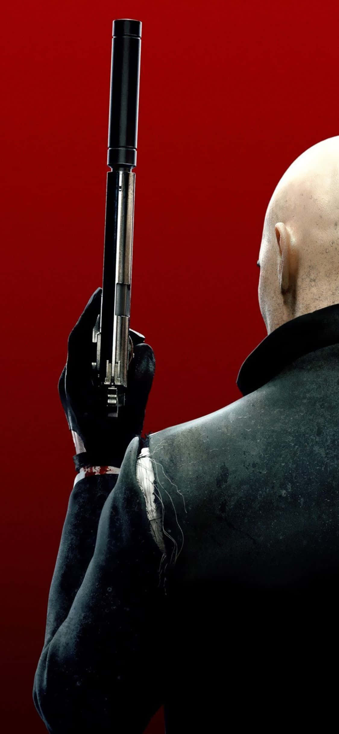 在 iPhone X 上體驗《Hitman Absolution》的自訂救贖之路 壁紙 — 一個光頭男子身穿黑色西裝，手持消音手槍，背景為鮮紅色。