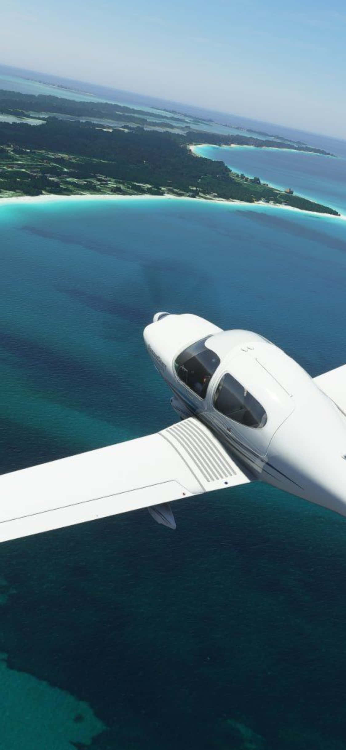 在 iPhone XS 上體驗 Microsoft Flight Simulator 的飛行快感 壁紙 — 一架白色單引擎飛機在晴朗藍天下翱翔於碧綠海水和翠綠島嶼之上。