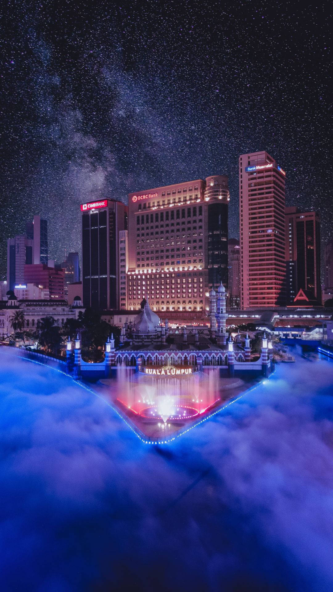 星空下，燈火通明的建築和發光的噴泉構成的夜景。