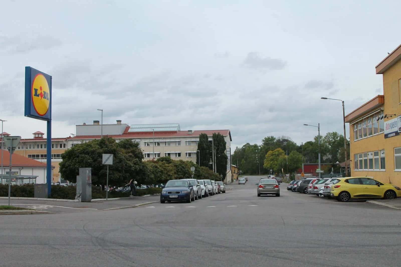 Norrköping 桌布 壁紙 — 在 Lidl 超級市場停車場的一個多雲天，停泊的汽車中有一輛黃色汽車格外顯眼。