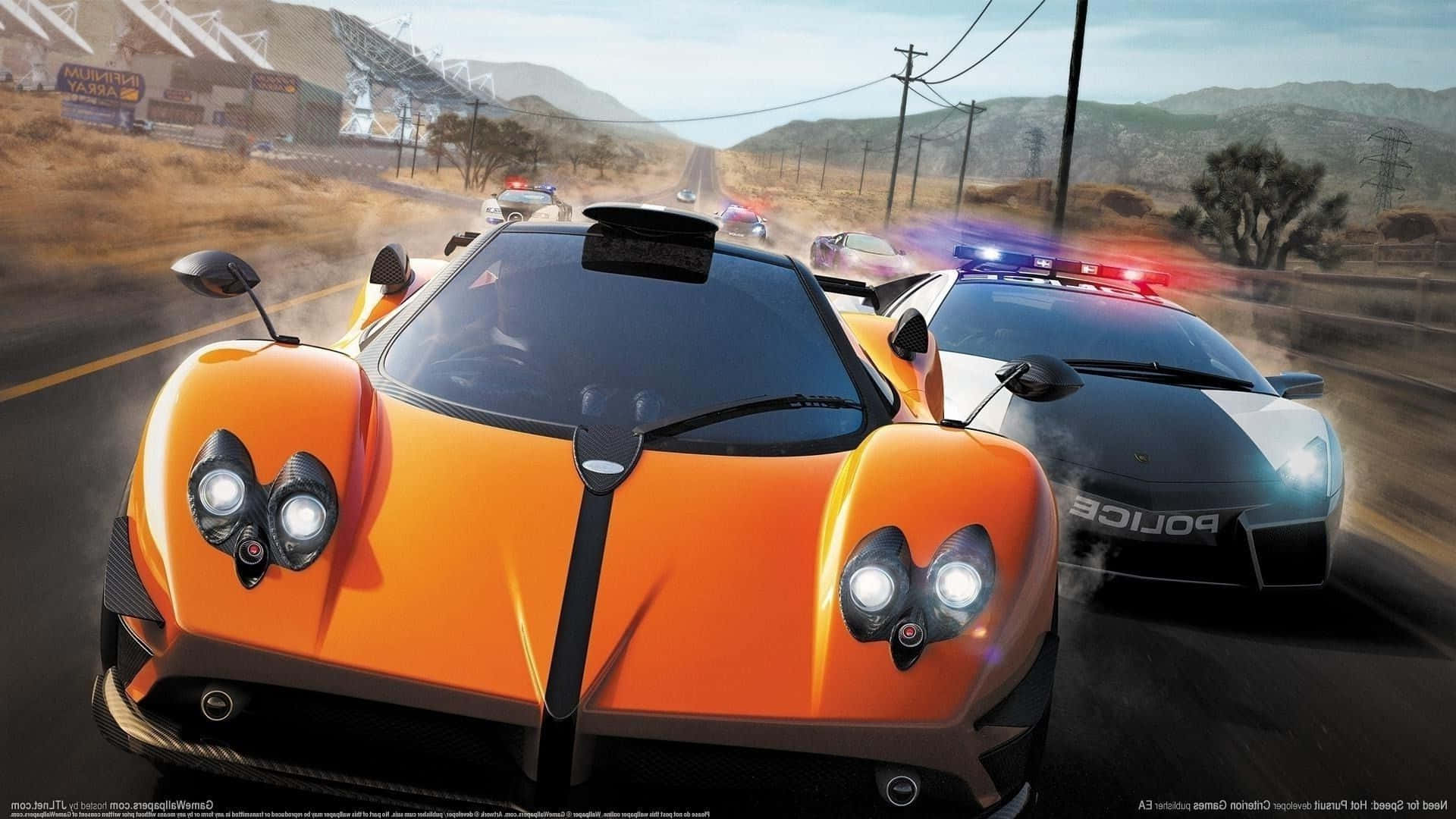 在《Need for Speed》中超越時間 壁紙 — 一輛橙色超跑在沙漠公路上飛馳，被一輛閃著警燈的警車追趕。